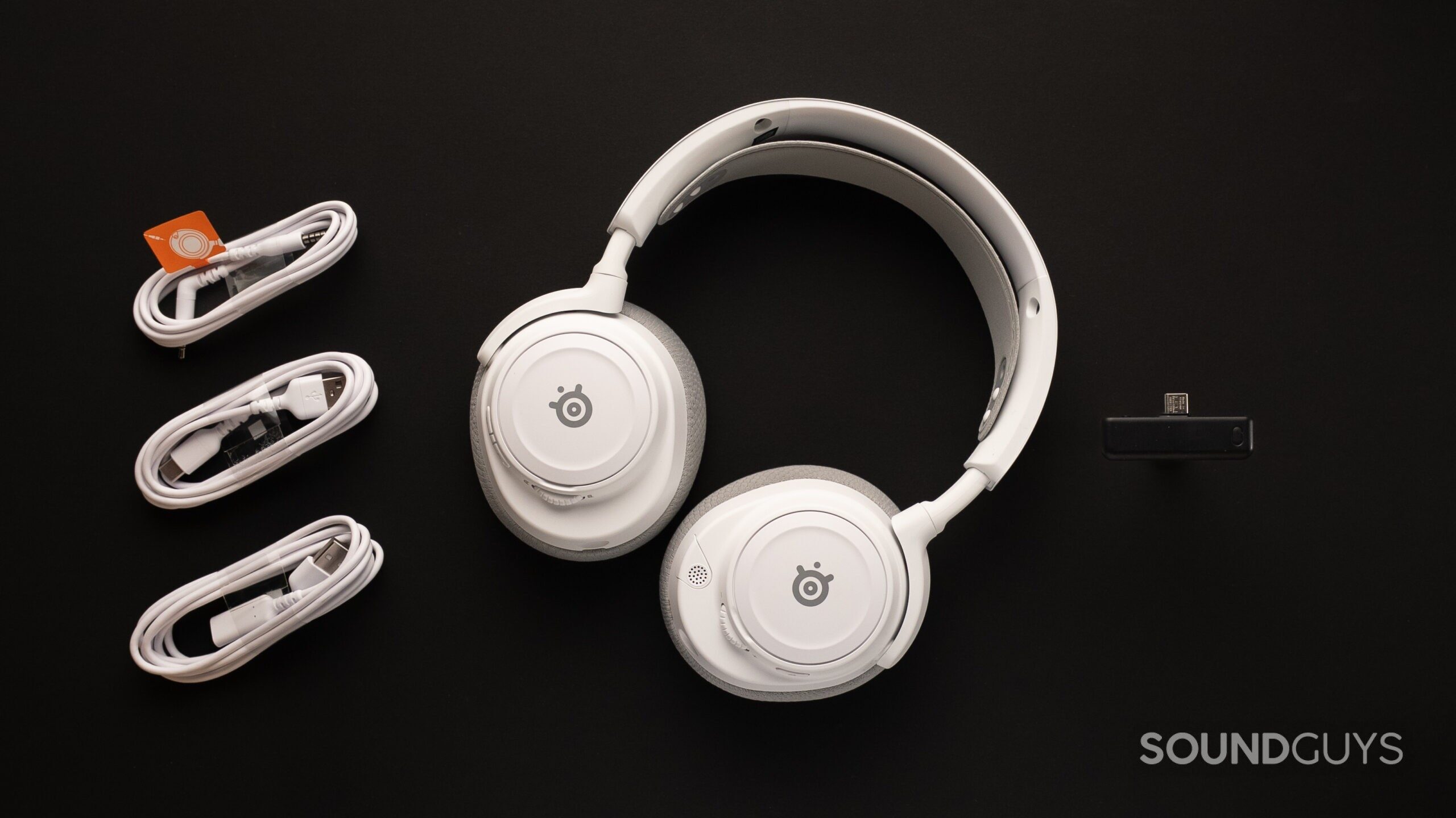 SteelSeries Arctis Nova 7 Gen 2 with accessories top down The SteelSeries Arctis Nova 7 Gen 2 laid out top down on a table.