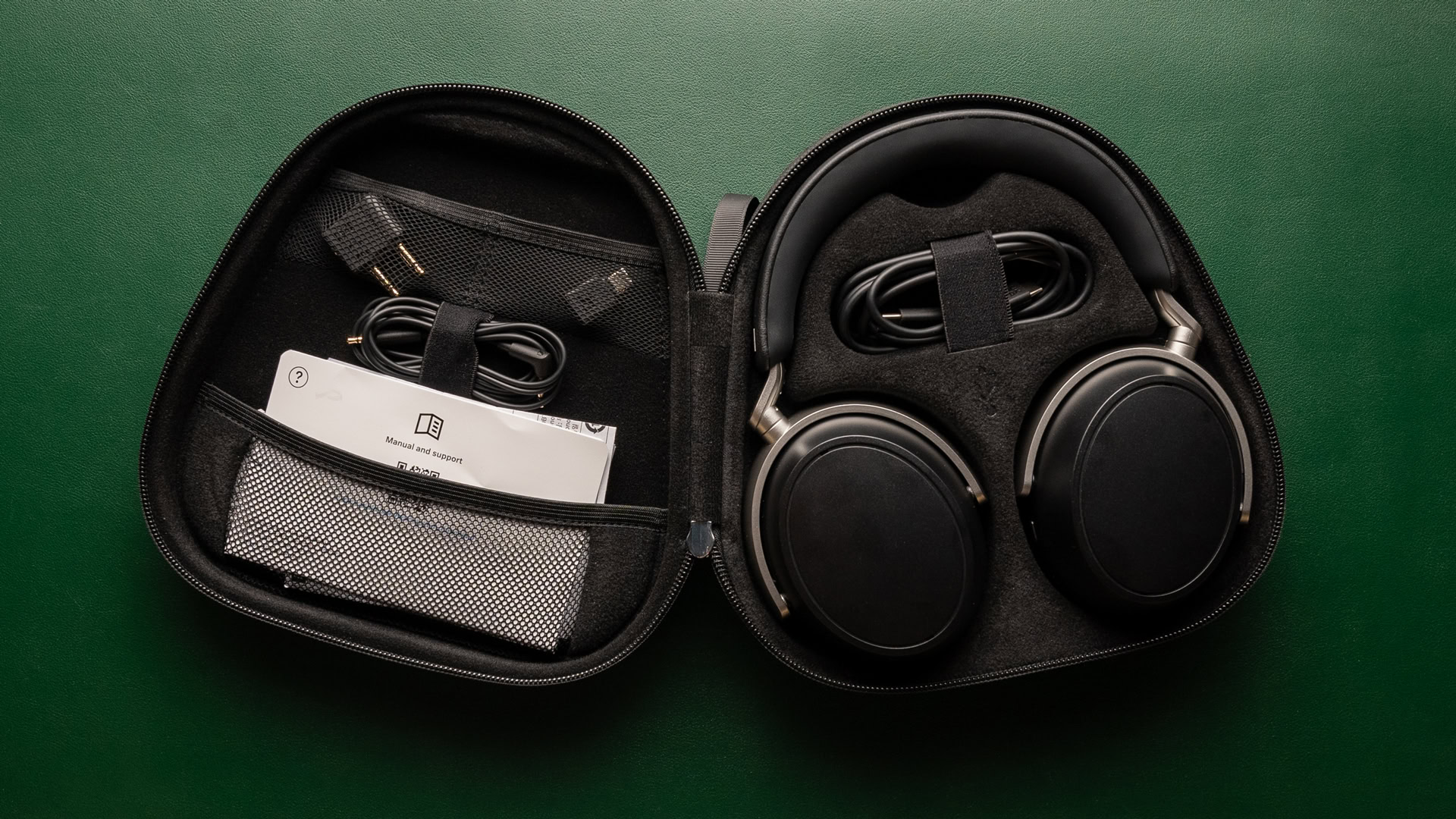 sennheiser-HDB-630-case A photo of the Sennheiser HDB 630's hard shell travel case, open to show contents, headphones, cables, documentation.