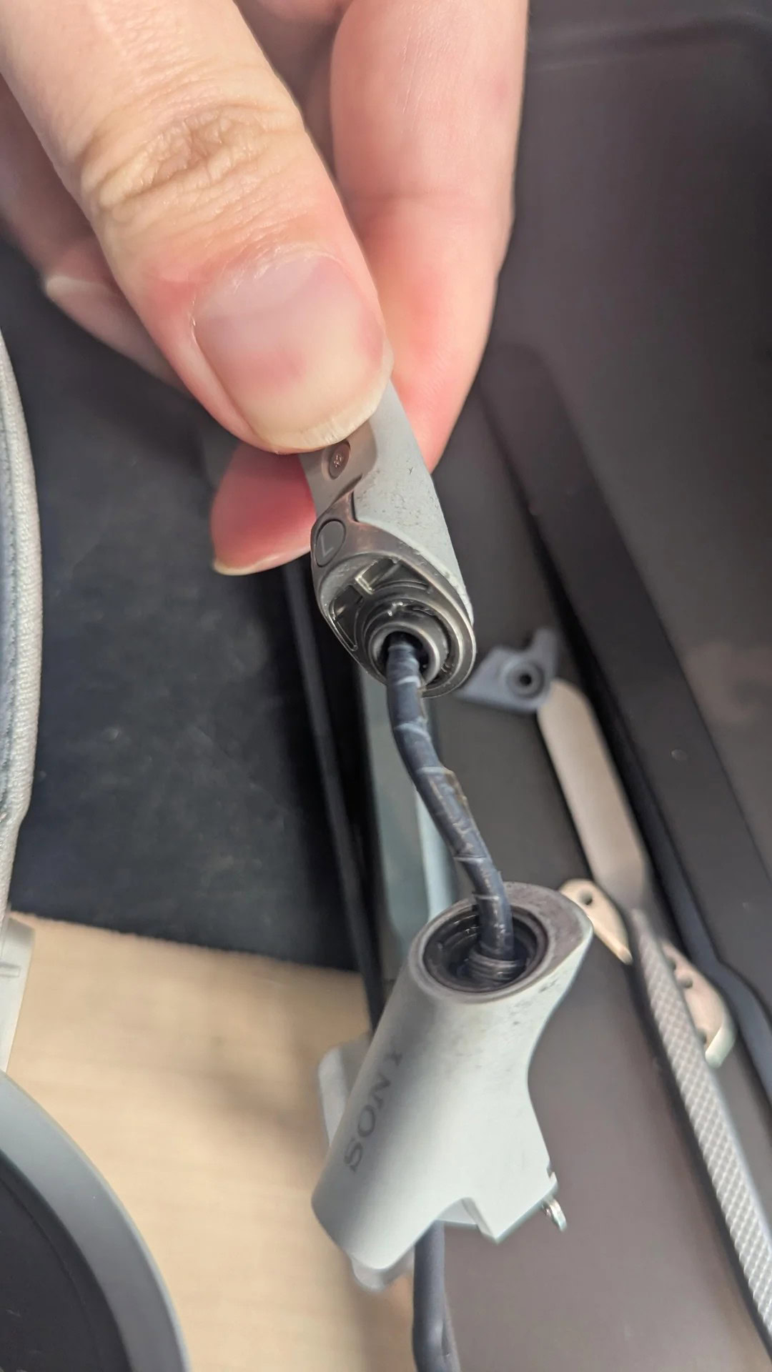 Shows the failed hinge. I'm grasping on the headband part of the hinge with the earcup part dangling.