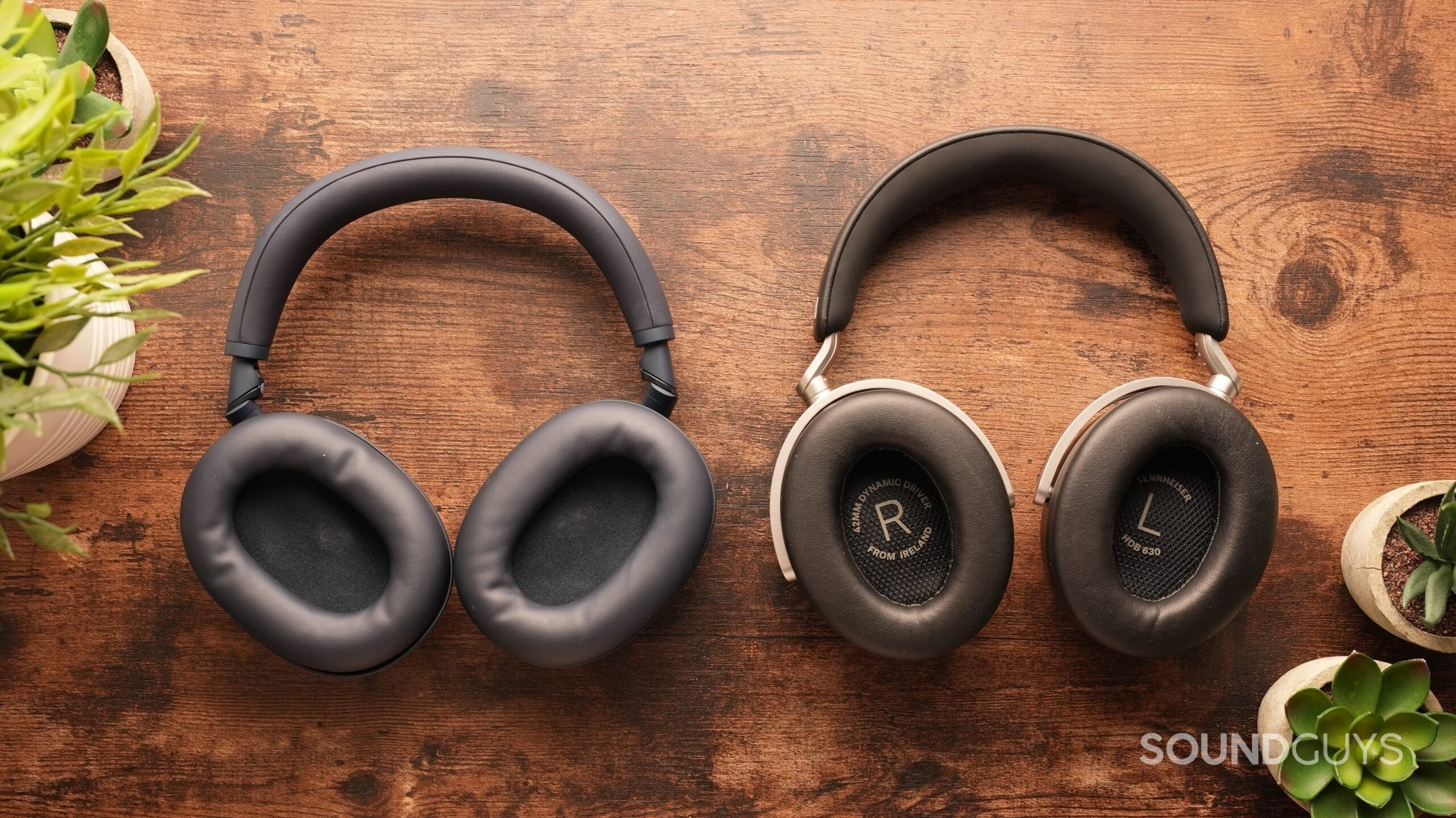 The Sony WH-1000XM6s and the Sennheiser HDB 630 sit side-by-side on a table, cups up.