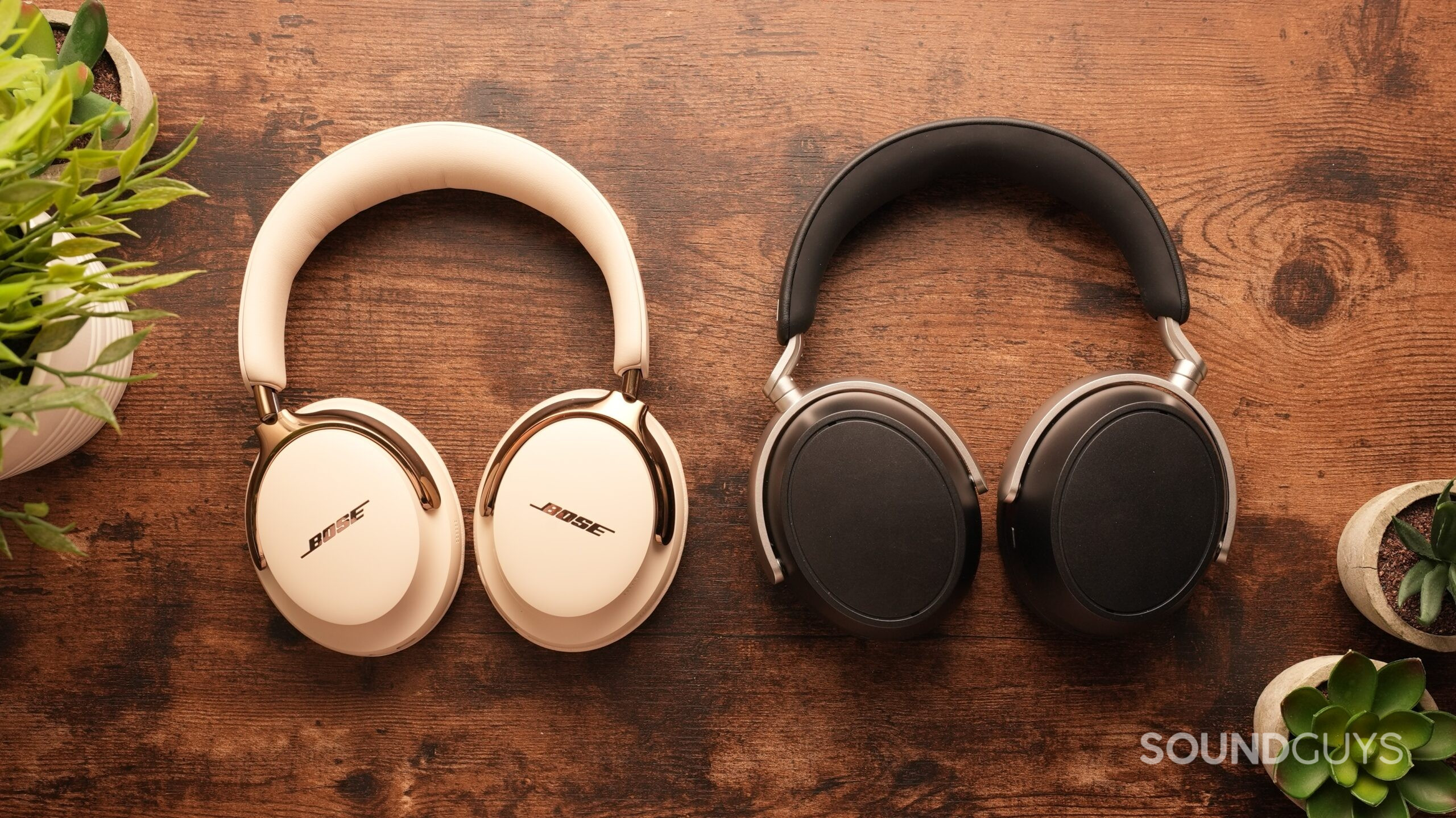 The Bose QuietComfort Ultra 2s and the Sennheiser HDB 630s sit side-by-side on a table, cups down.