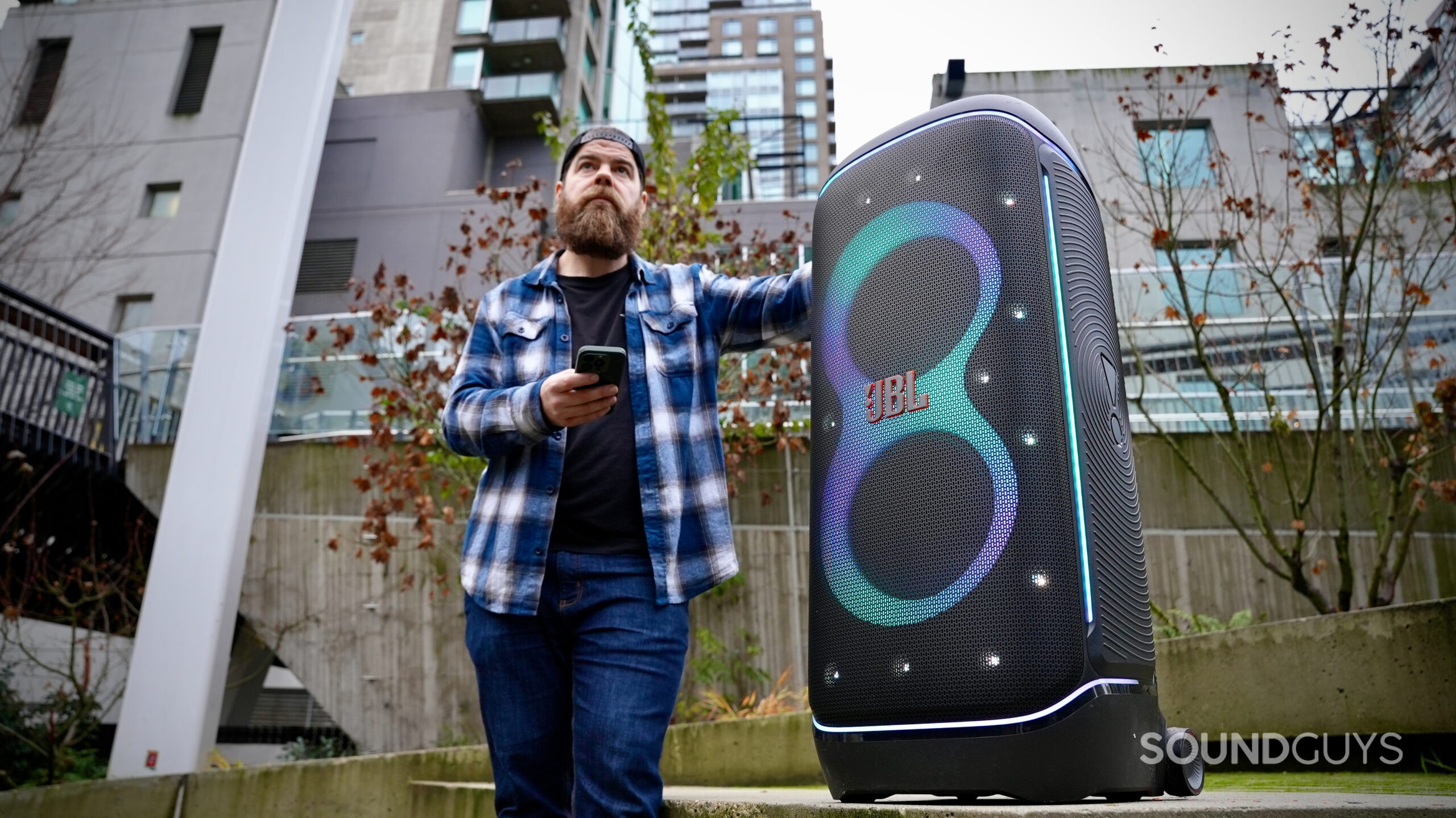 JBL PartyBox 720 (2) - 2 A man standing next to JBL PartyBox 720 in an outdoor setting.