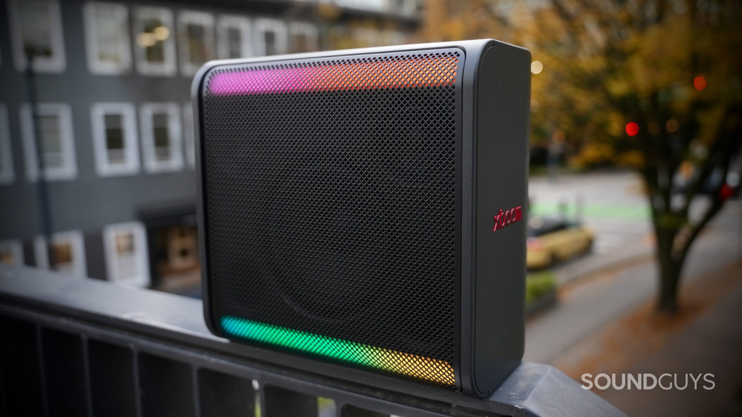 An LG xboom Stage 301 speaker placed on a railing in a city setting.