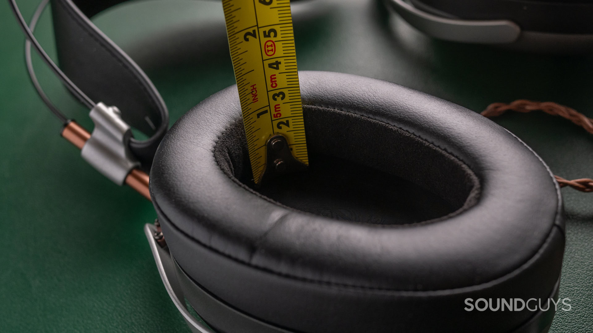 A photo of the Meze Audio Poet with a tape measure showing the ear pad depth.