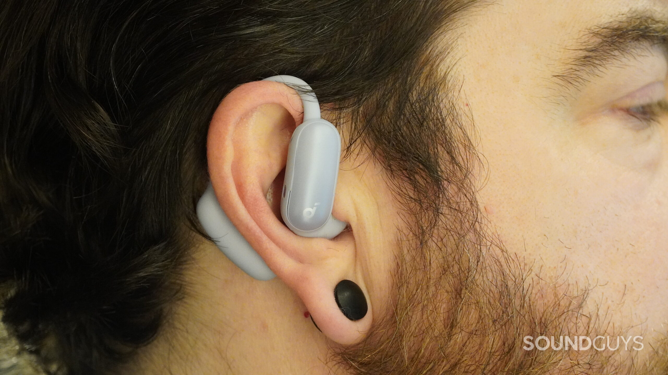 The Soundcore AeroFit 2 Pro on a mans ear.