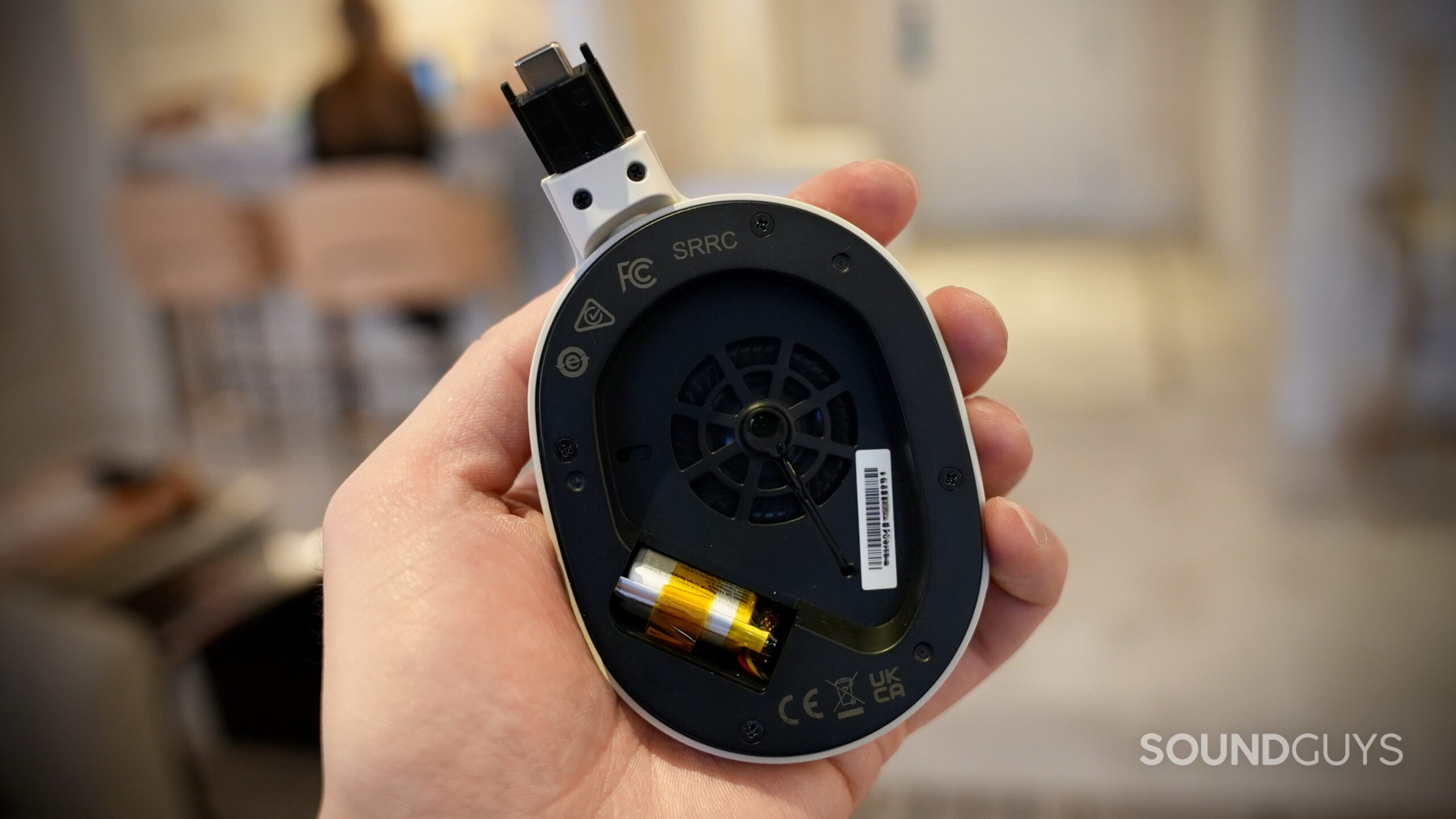 A Fender MIX earcup with its pads and battery door removed, exposing its replaceable battery.