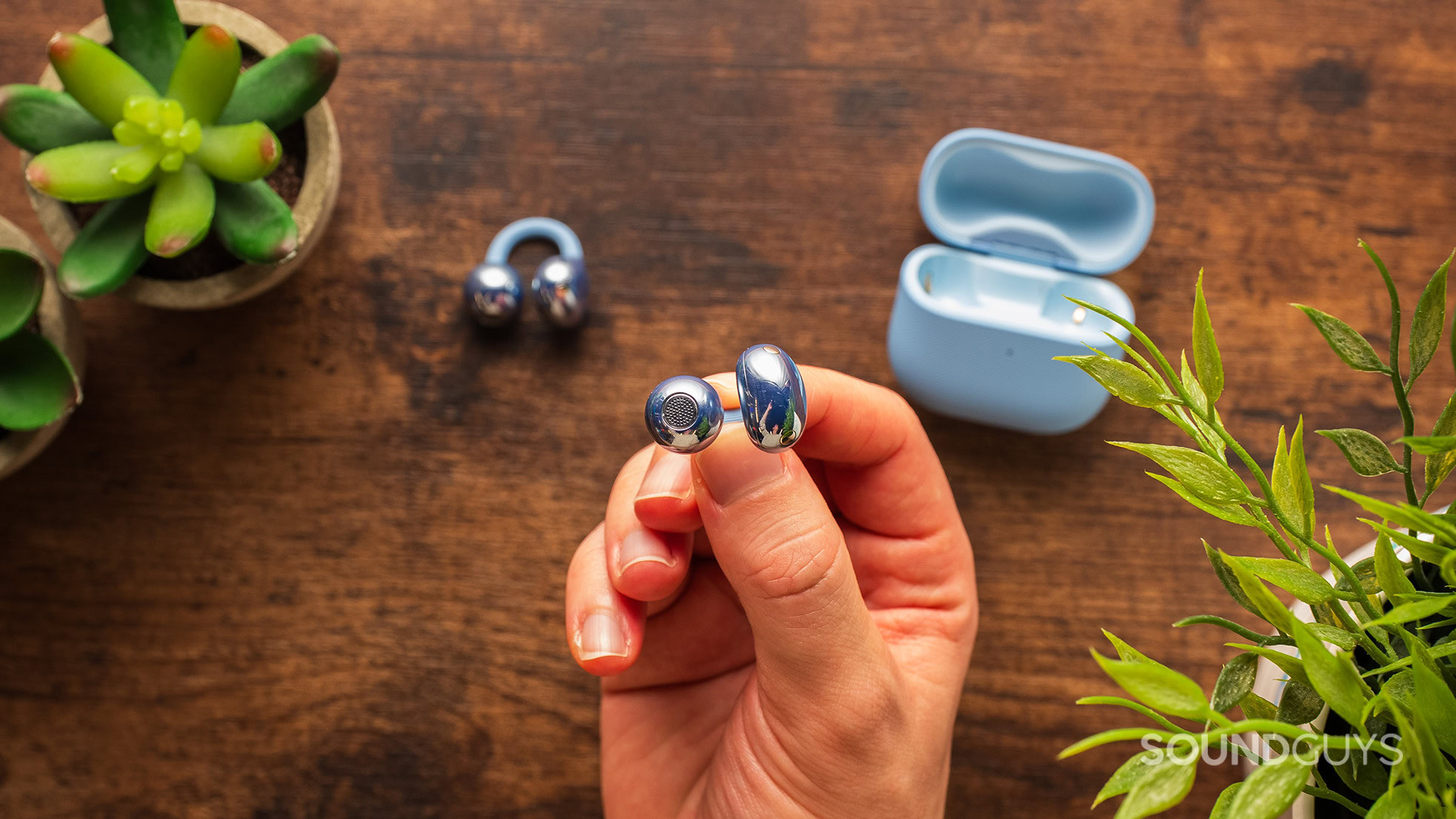 HUAWEI FreeClip 2 earbuds held in hand.