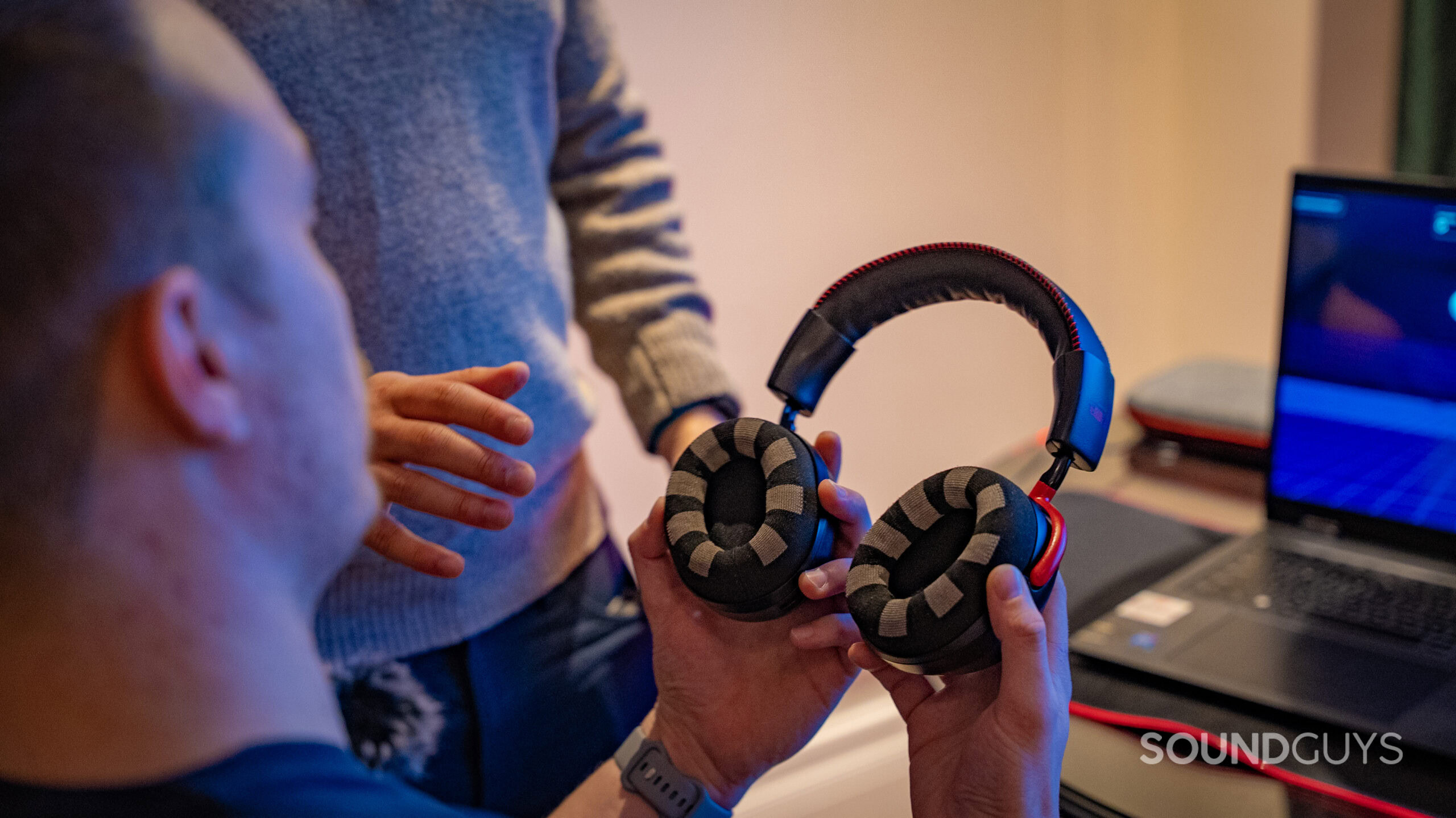 A man holding the Neurable HyperX headset showing the EEG earpads