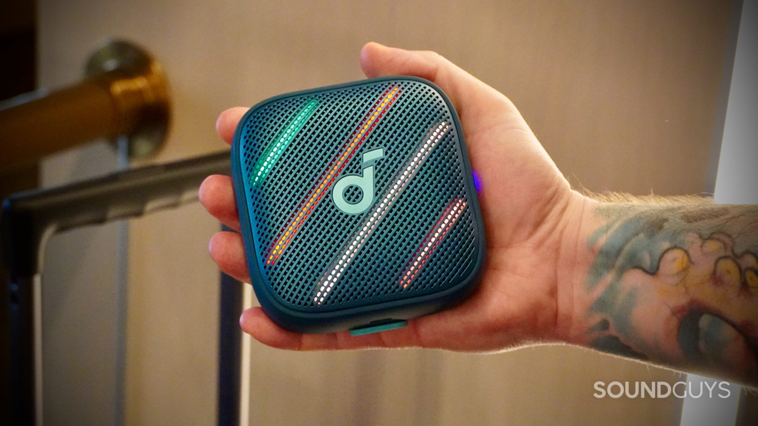 A Soundcore Boom Go 3i in the palm of a man's hands.