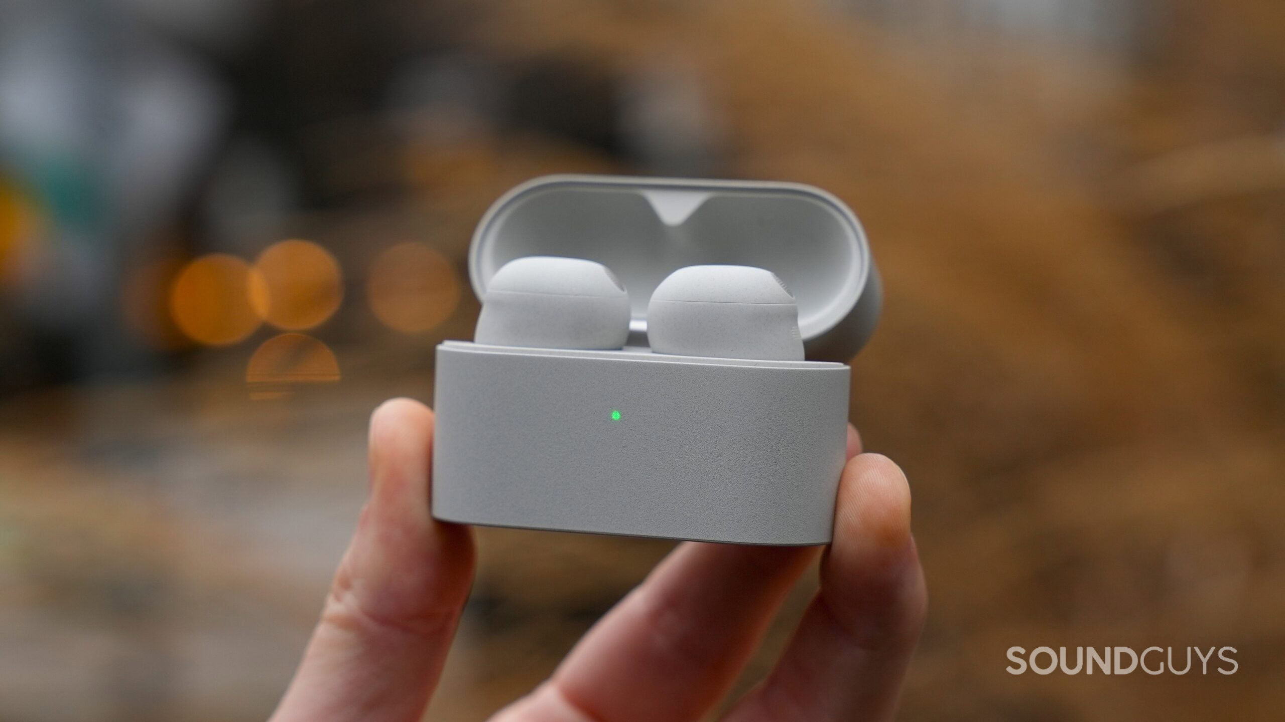 a hand holding the sony wf-1000xm6 inside case with the lid open