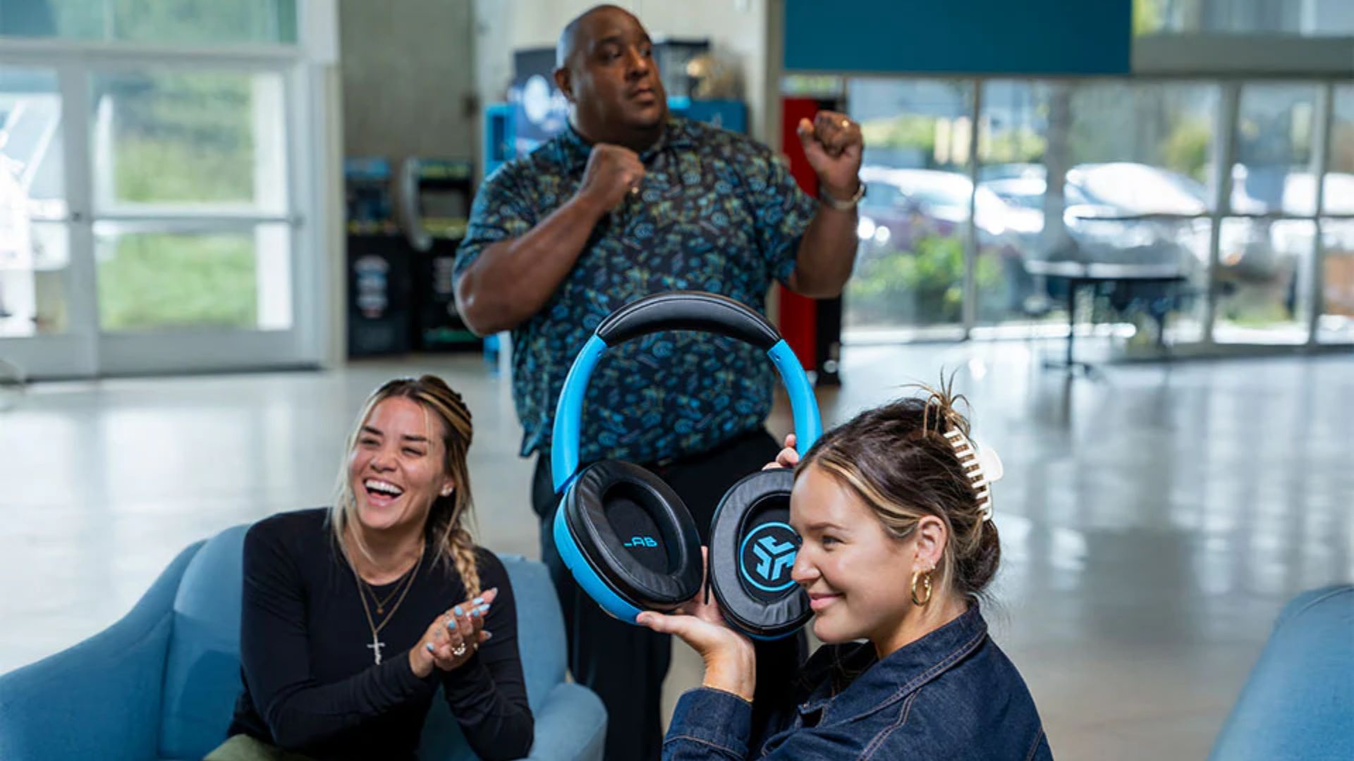 A photograph of the JLab Blue XL Speaker Headphones being used by a group.