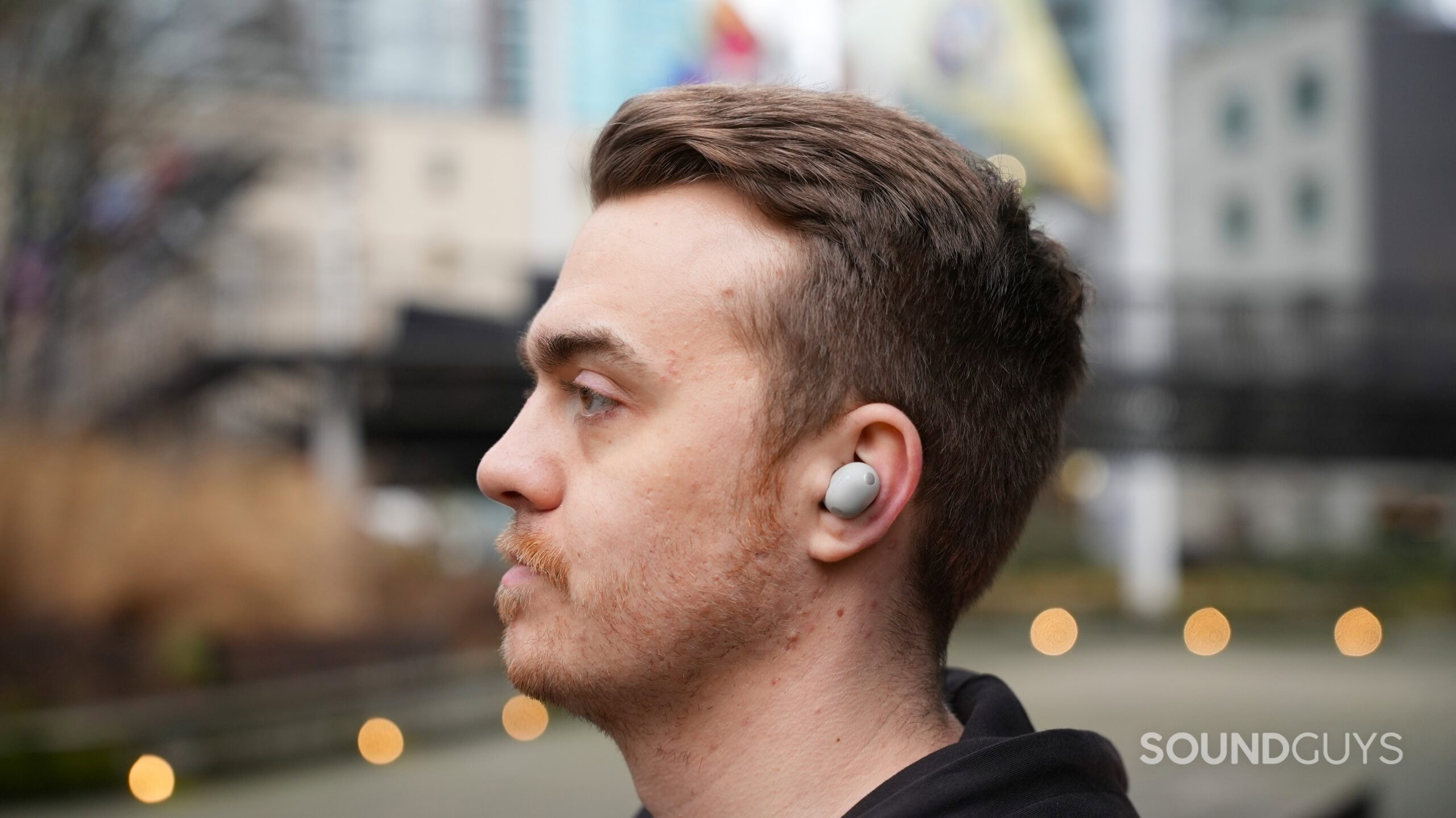a man wearing the sony wf-1000xm6 earbuds outside a man wearing the sony wf-1000xm6 earbuds outside