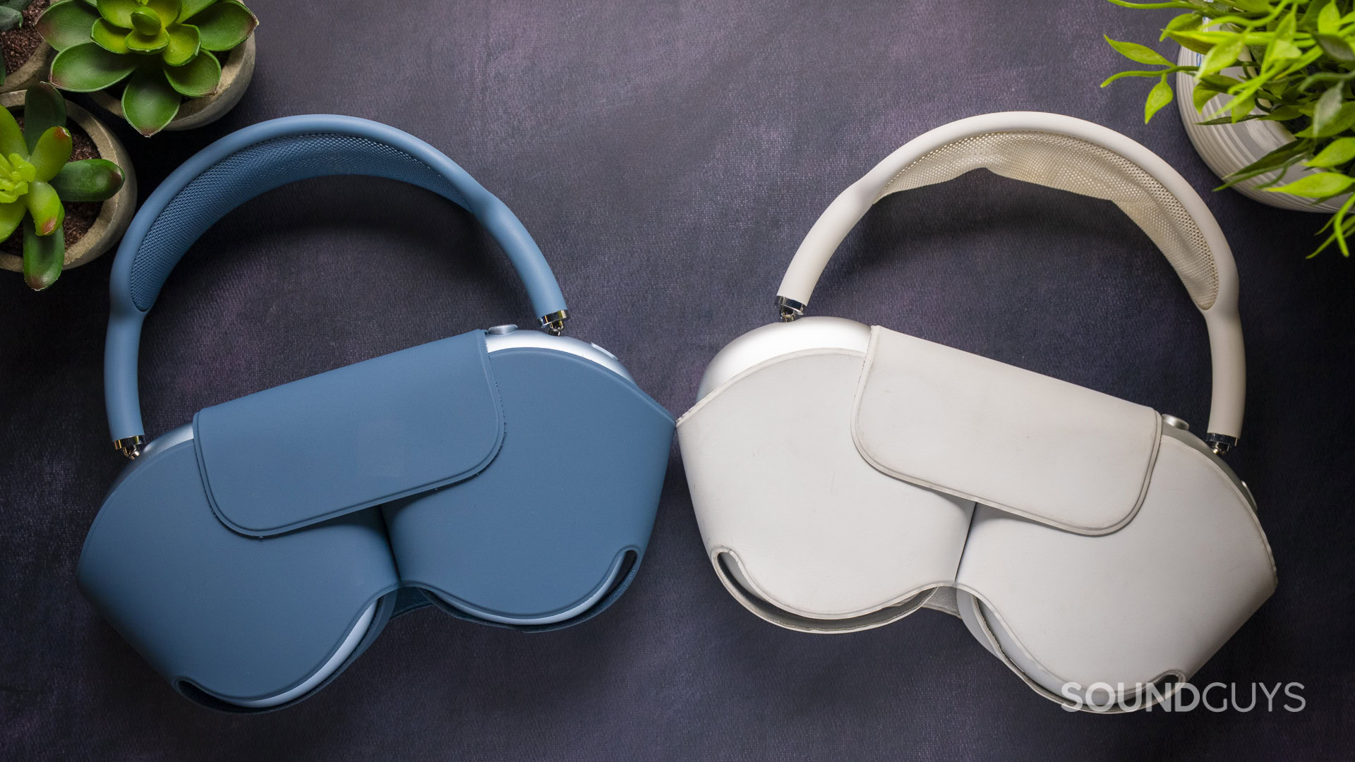 Apple AirPods Max 2 vs Apple AirPods Max 1-14 Apple AirPods Max 2 in blue (left) and AirPods Max 1 in silver (right) placed inside their Smart Cases on a dark surface.