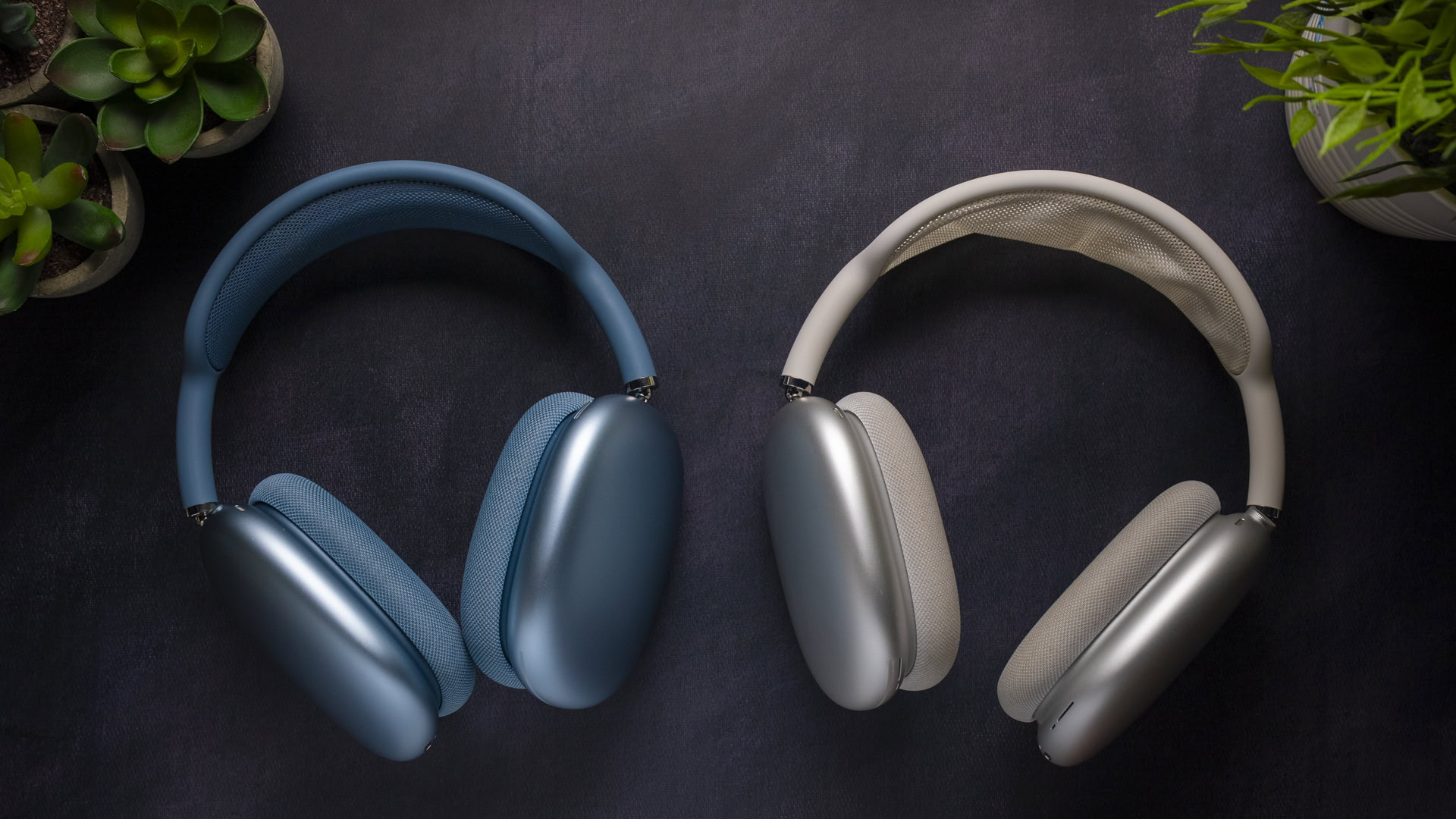 Apple AirPods Max 2 vs Apple AirPods Max 1-4 Apple AirPods Max 2 in blue (left) and AirPods Max 1 in silver (right) held in hands with ear cushions facing forward.