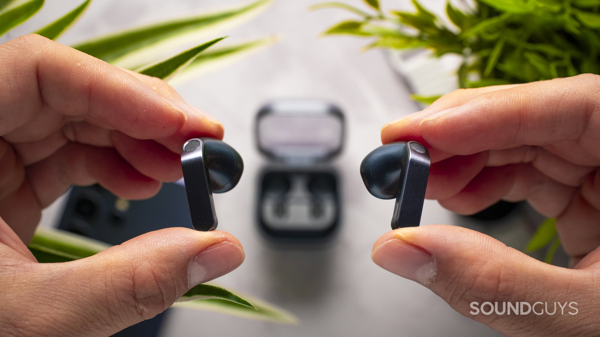 Holding the samsung galaxy buds4 earbuds
