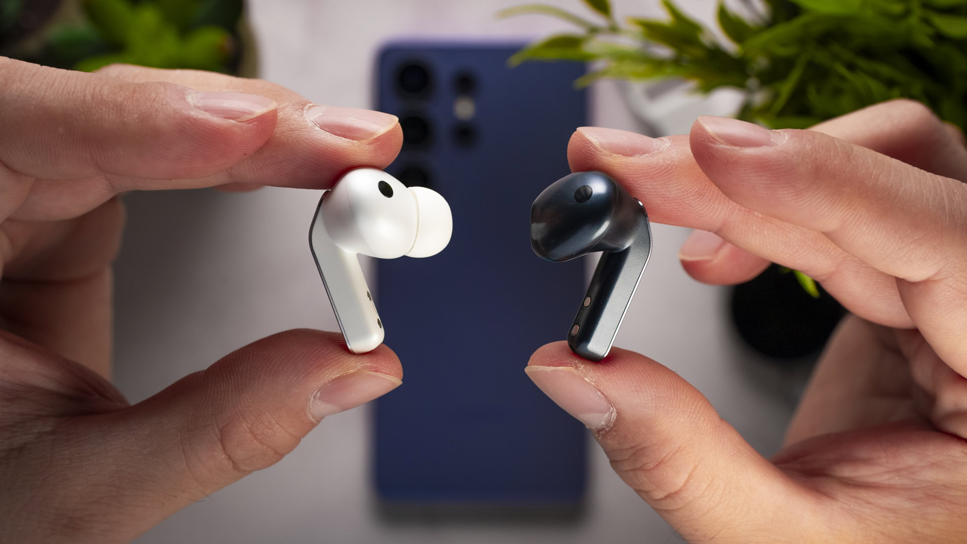 Holding the Samsung Galaxy Buds 4 and 4 Pro earbuds