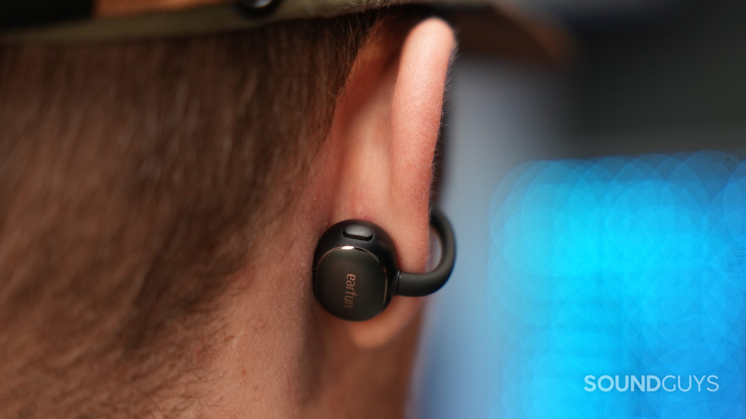 Close the EarFun Clip 2 earbud to the ear, showing the outer housing with the EarFun logo and attached to the curved piece.
