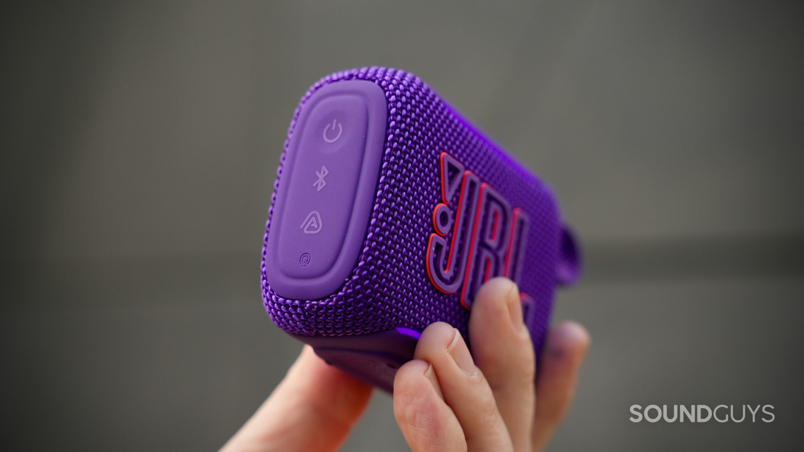 A close-up of the JBL Go 5 side panel showing the power, Bluetooth, and pairing buttons.