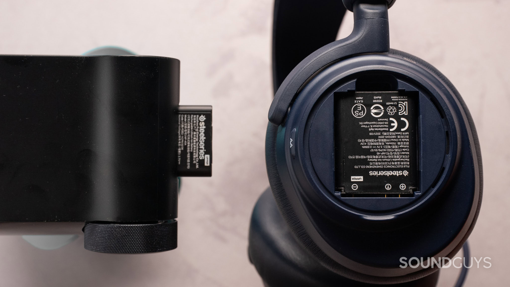 SteelSeries Arctis Nova Pro Omni batteries SteelSeries Arctis Nova Pro Omni with the batteries out, of the base and side of earcup.