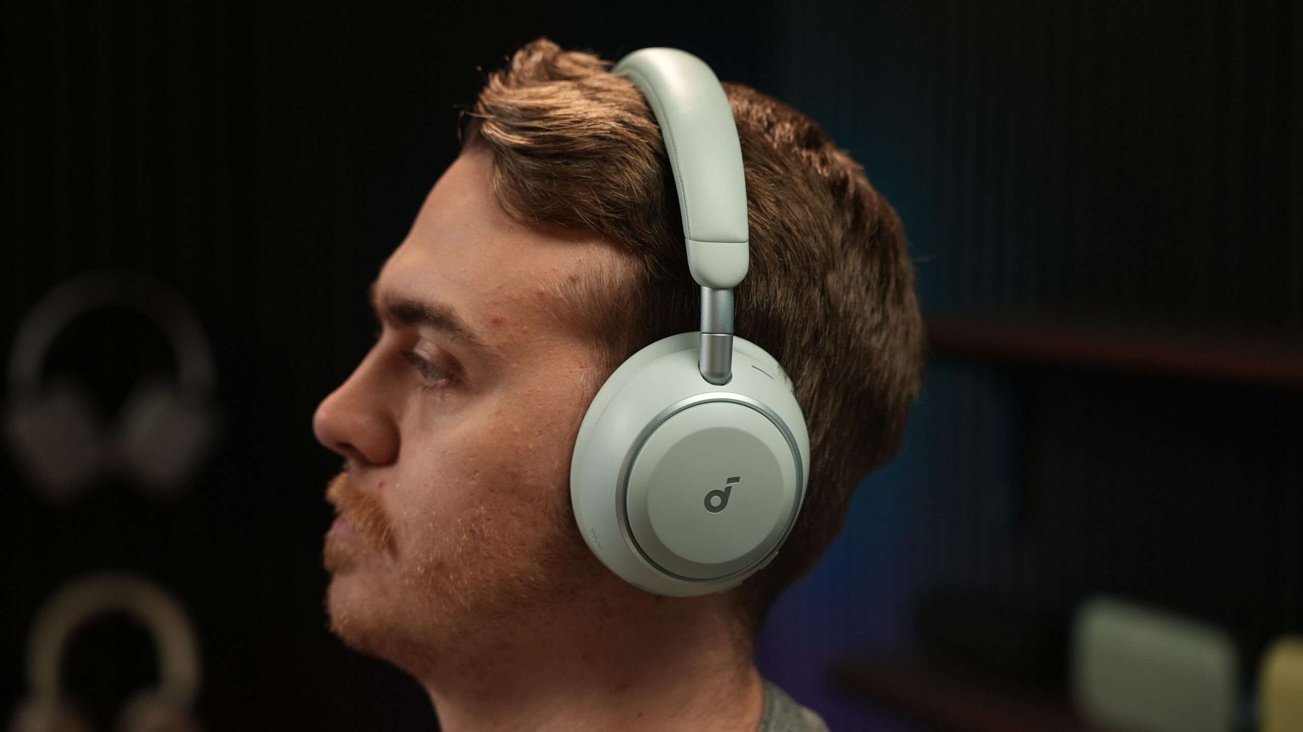 a man listening to the anker soundcore space 2 Man wearing light green Soundcore Space 2 over-ear headphones, shown from the side to highlight fit and earcup size.