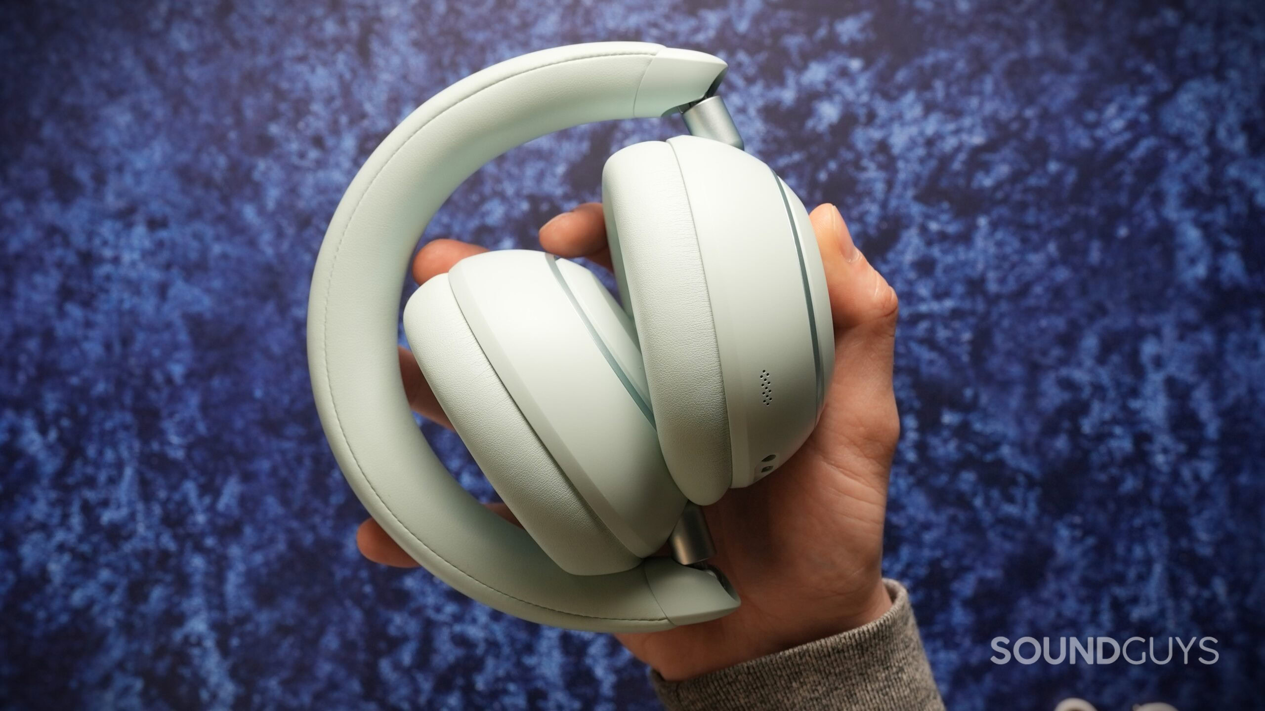 Soundcore Space 2 headphones folded inward and held in one hand, highlighting the compact, travel-friendly design.
