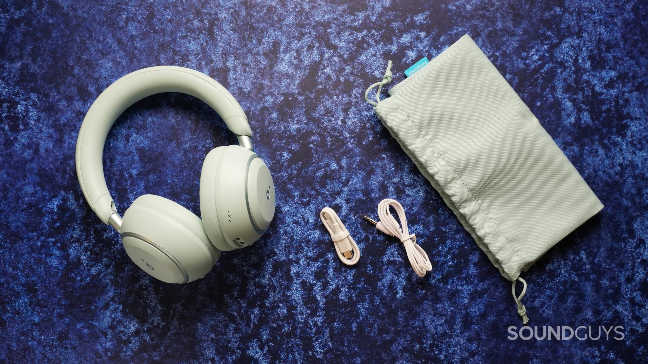 anker soundcore space 2 with bag and cables Soundcore Space 2 headphones with included carrying pouch, USB-C charging cable, and 3.5mm audio cable laid out on a blue background.
