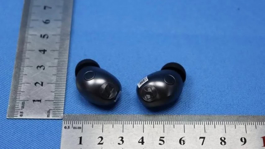 Sennheiser Momentum True Wireless 5 earbuds outside their charging case, showing the rounded housing and Sennheiser logo faceplate