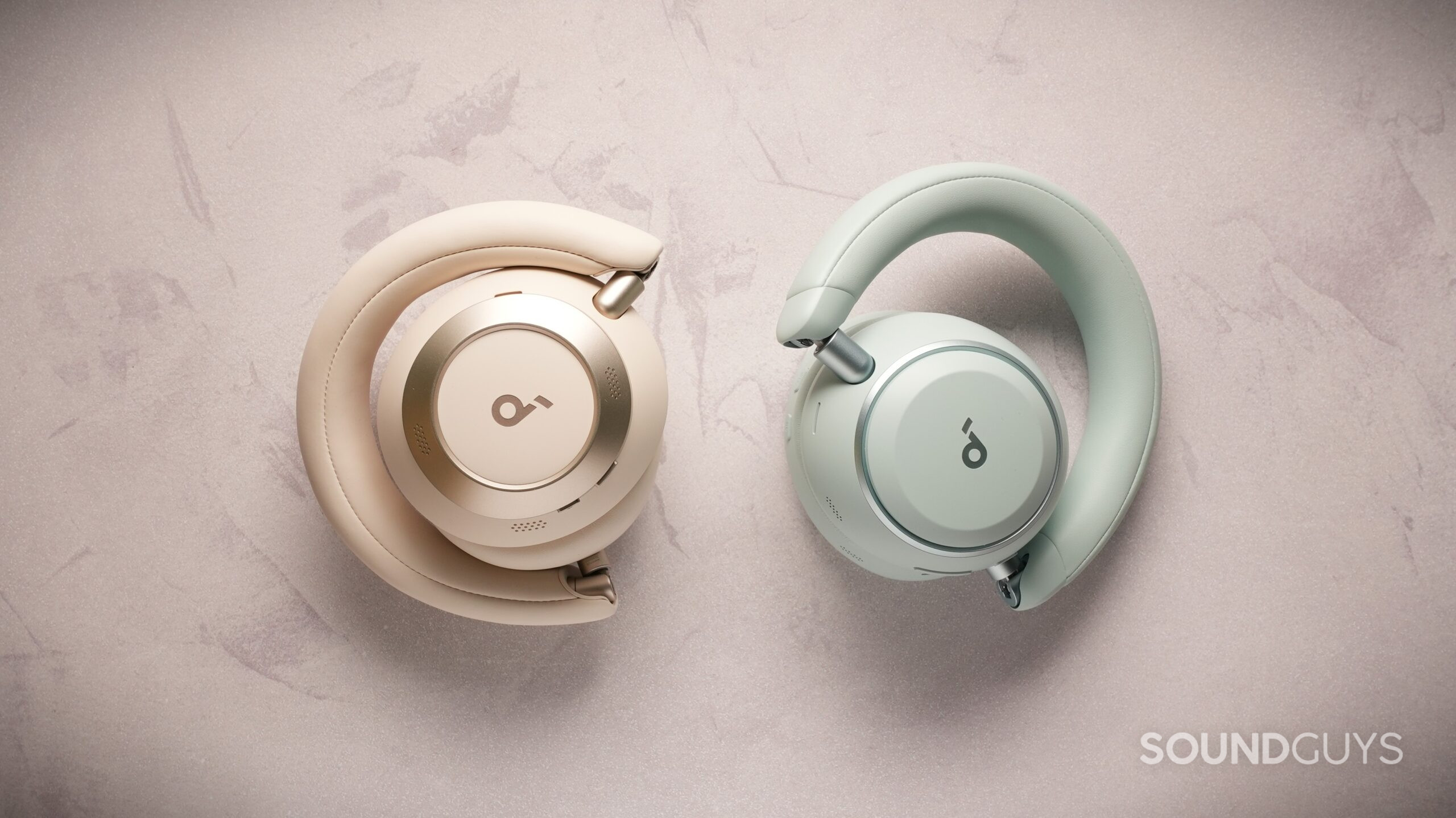 soundcore space 2 and space one pro folded Beige and green Soundcore over-ear headphones folded inward, demonstrating the compact, travel-friendly hinge design.