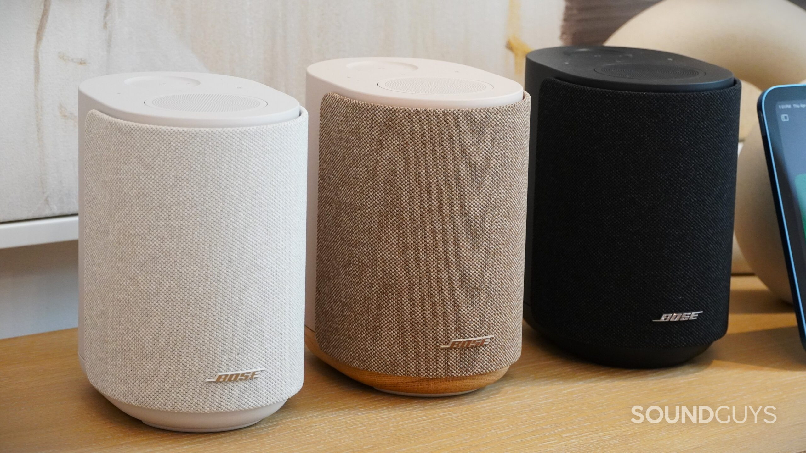Bose LifeStyle Ultra speakers Three Bose smart speakers in white, beige, and black finishes arranged side by side.