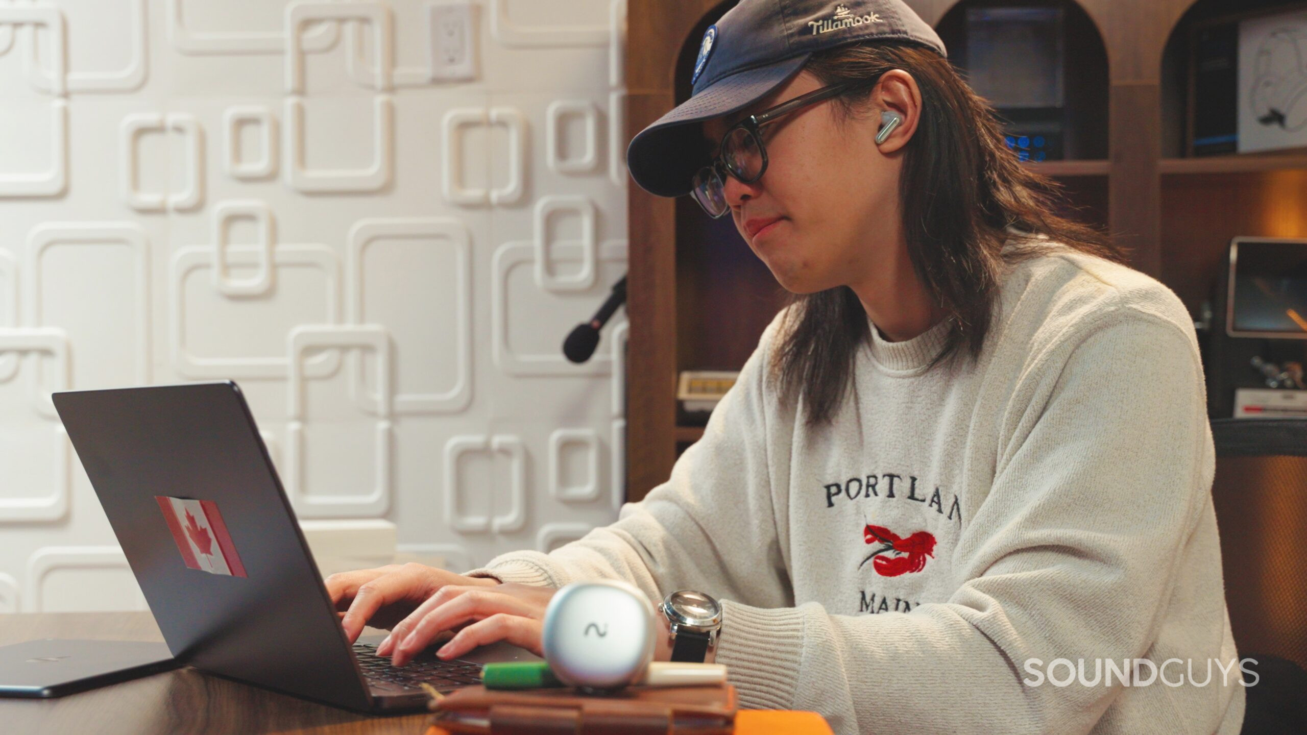a man working at a desk using Viaim RecDot earbuds.