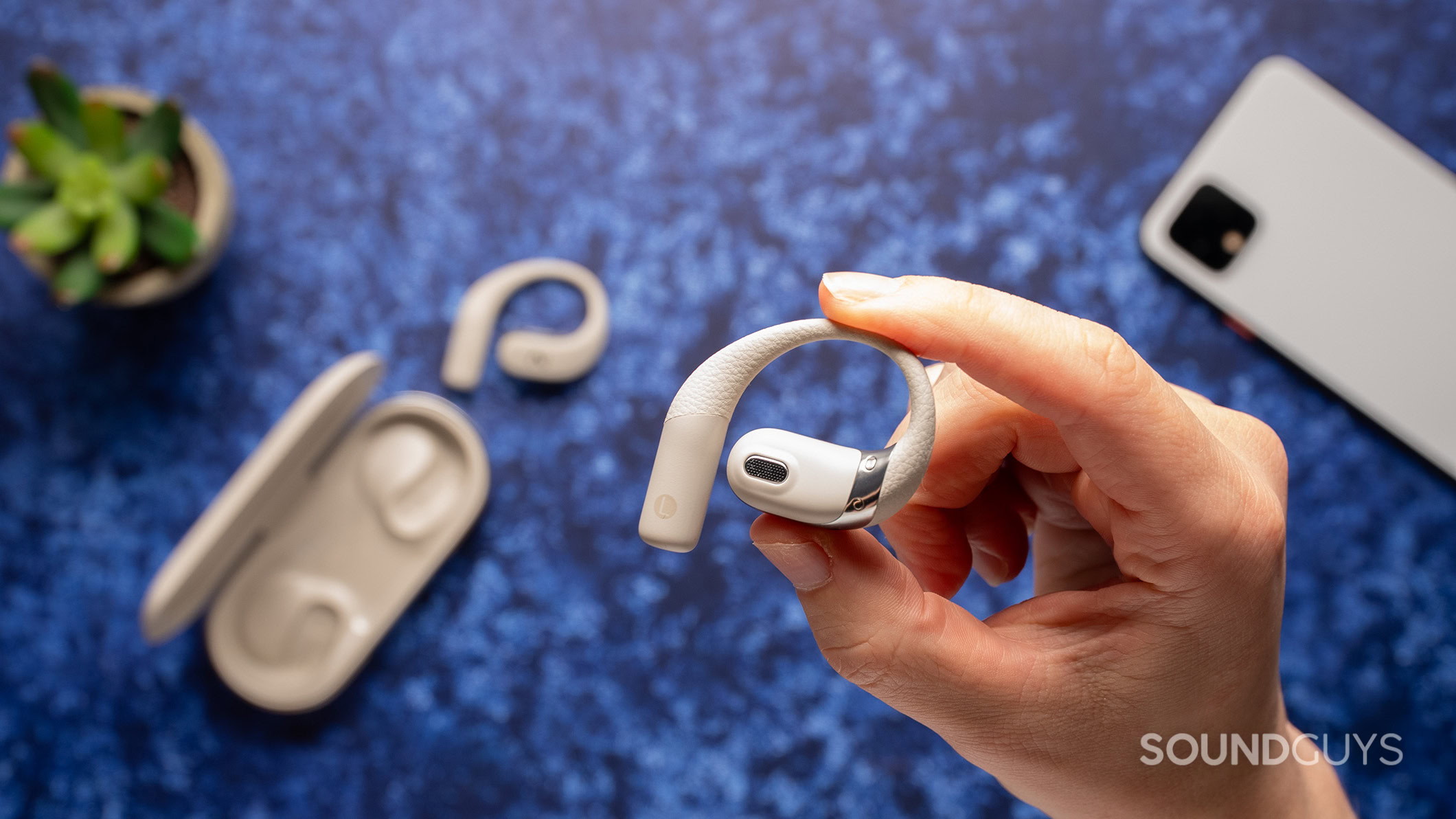 Hand holding Viim OpenNote earbuds.