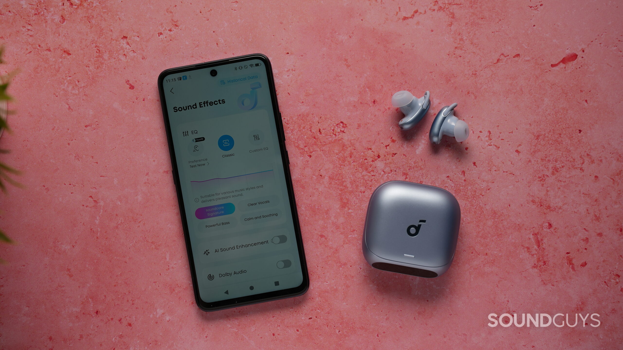 Smartphone displaying the Soundcore app sound effects menu beside the Soundcore Liberty 5 Pro earbuds and charging case on a pink tabletop.
