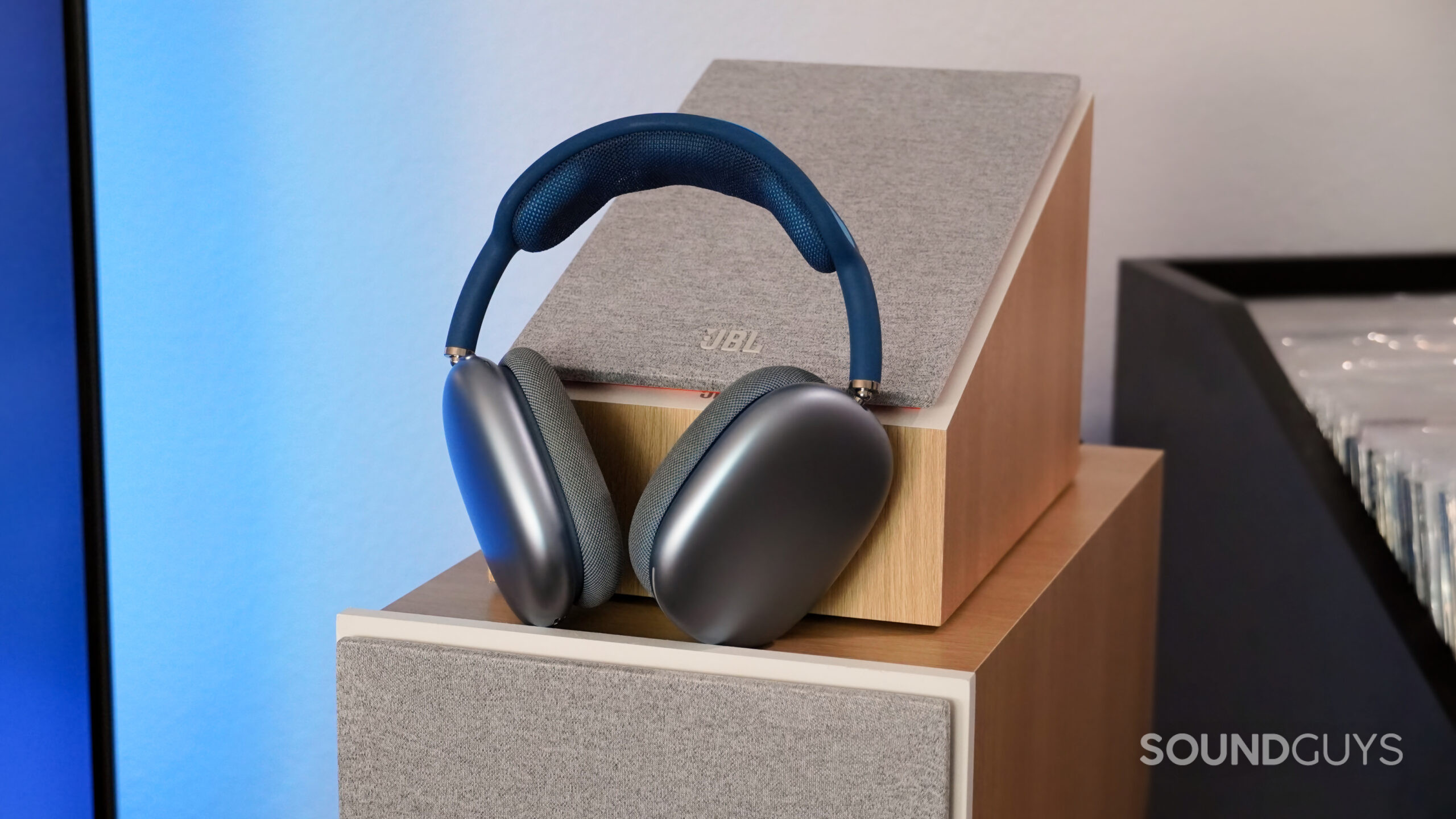 AirPods Max resting on front loudspeakers in front of upfiring speakers.