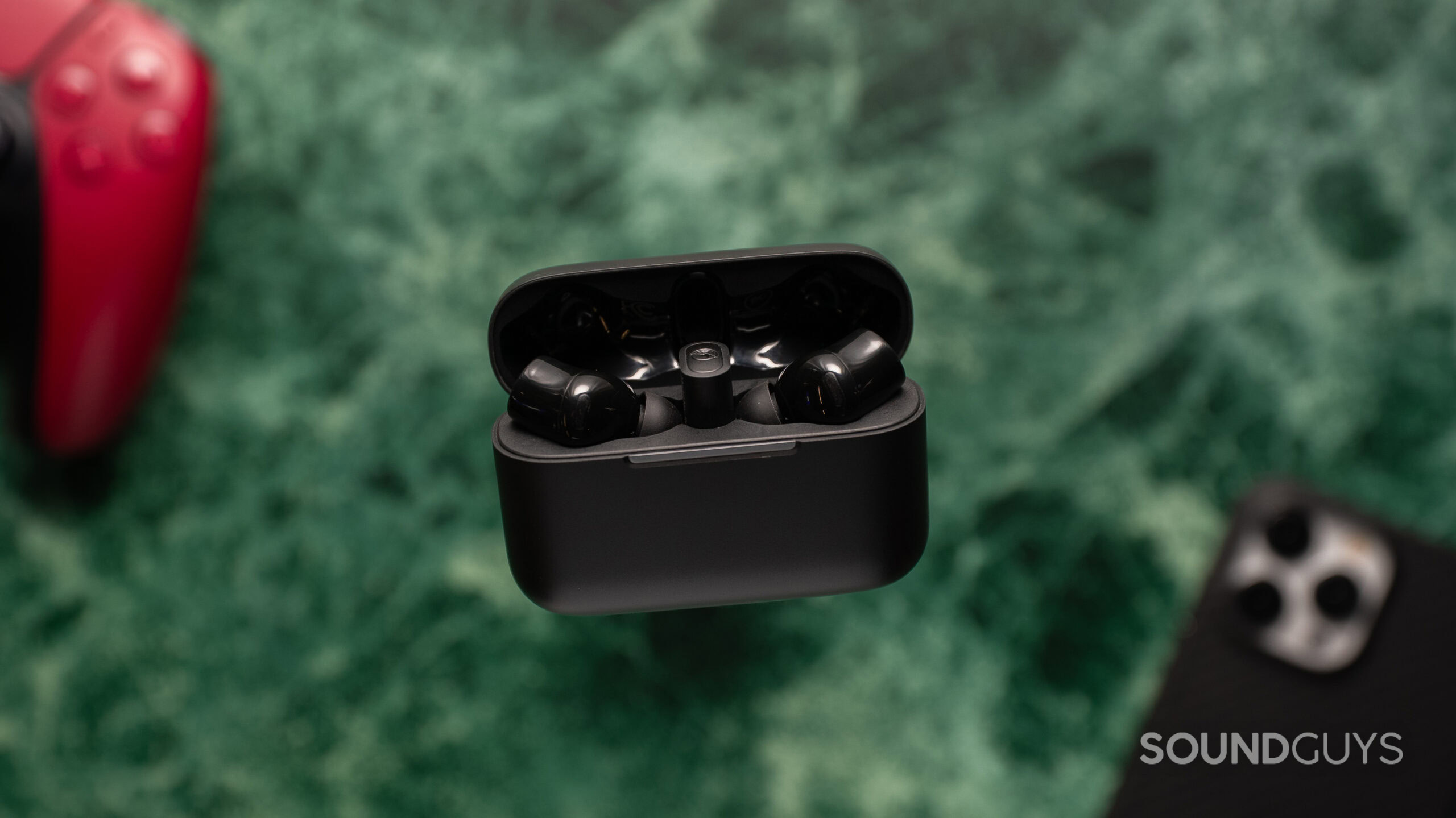 Razer Hammerhead V3 Hyperspeed top down with a controller and phone in the background.
