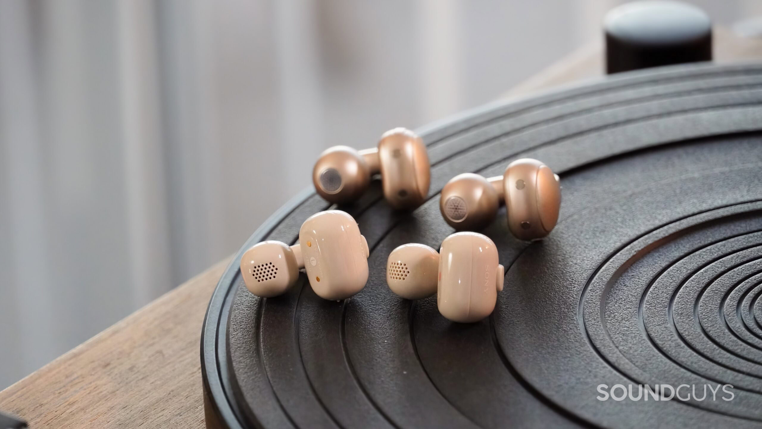 The Sony LinkBuds Clip and Motorola Moto Buds Loop on a turntable.