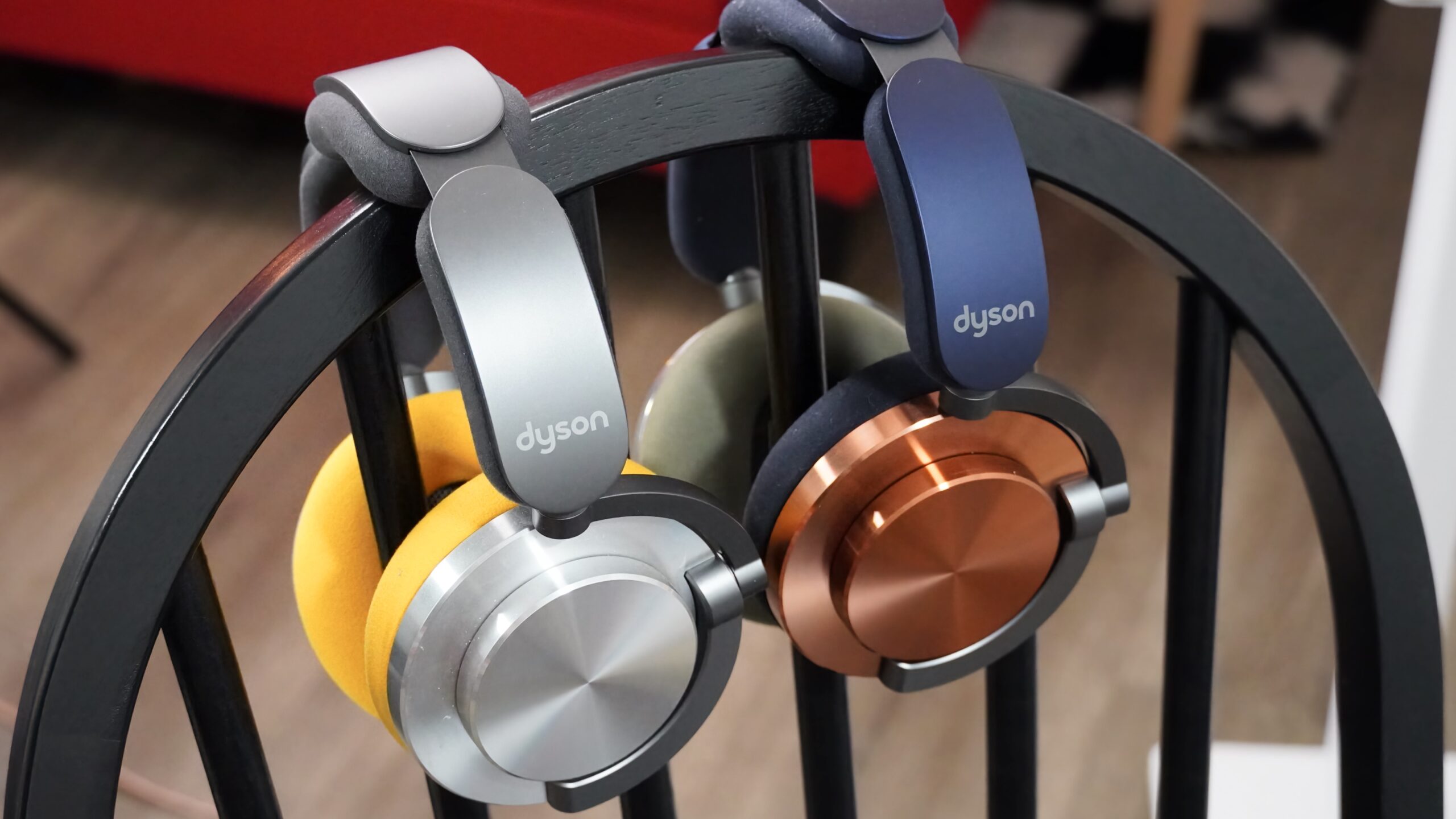 Dyson-OnTrac-4 Two colors of Dyson OnTrac headphones together hanging from a chair.