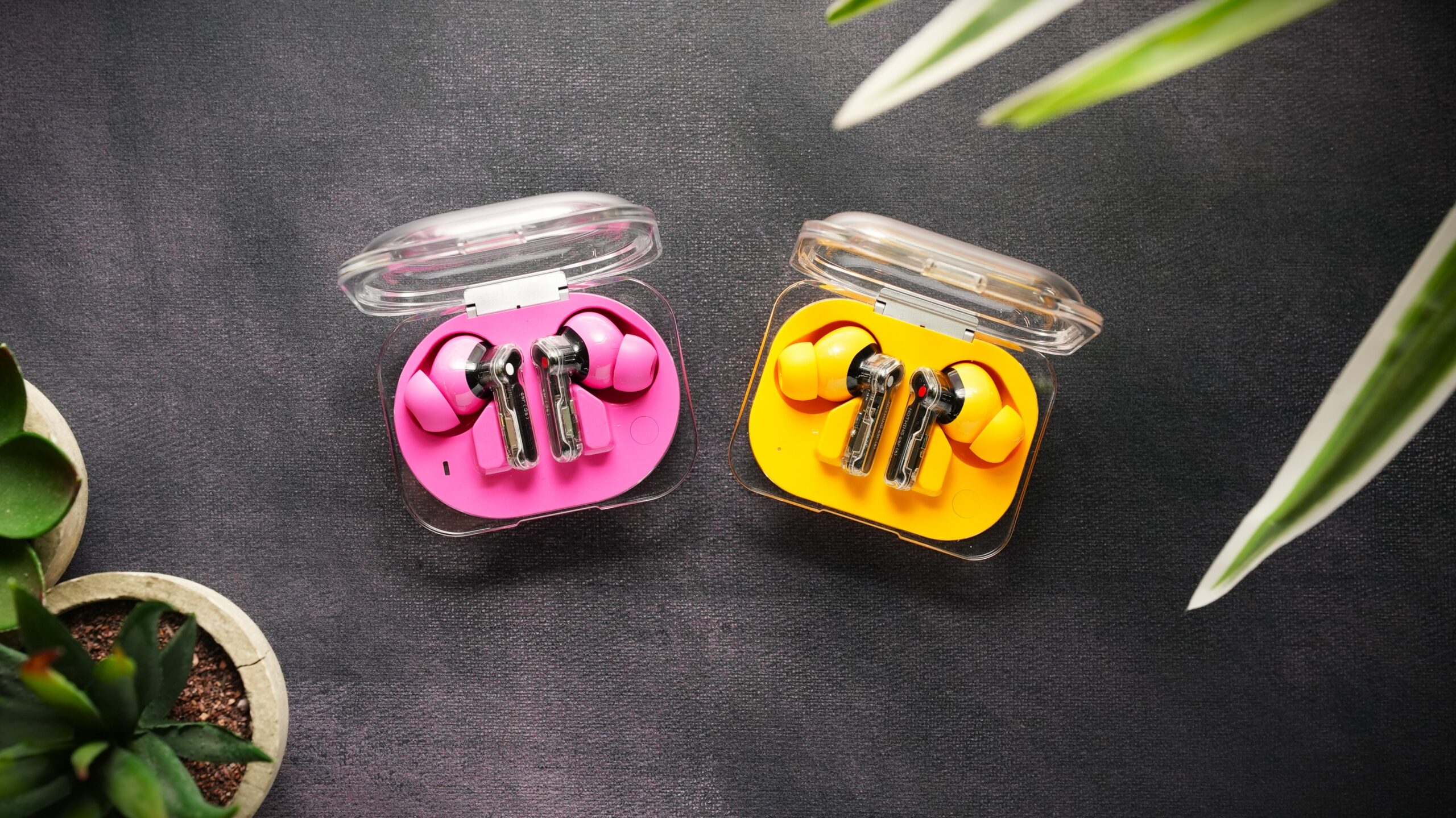 Nothing ear 3a vs Ear a (2) Nothing ear 3a in pink vs Ear a in yellow, earbuds on surface