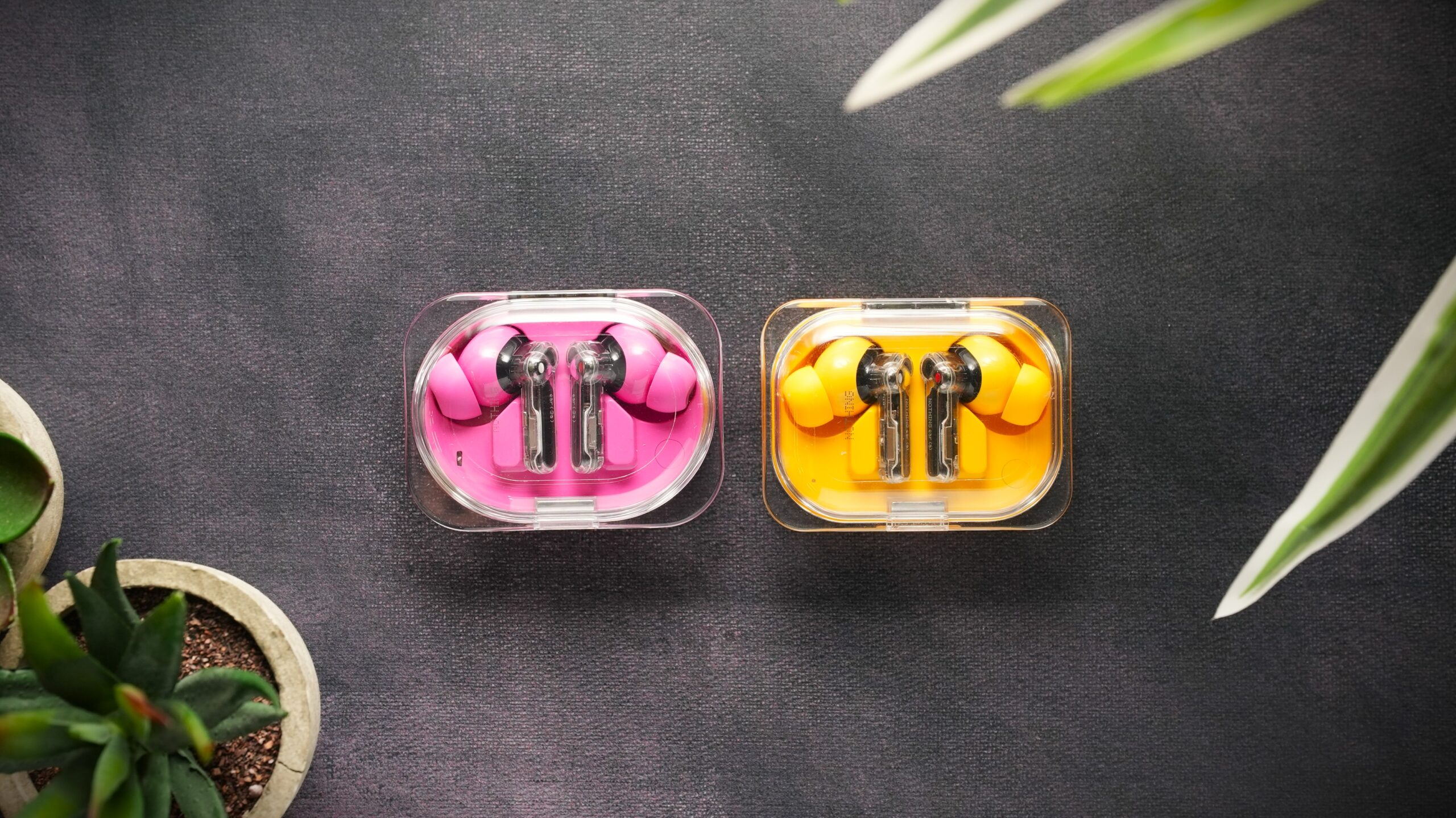 Nothing ear 3a vs Ear a Nothing ear 3a in pink vs Ear a in yellow, earbuds on surface