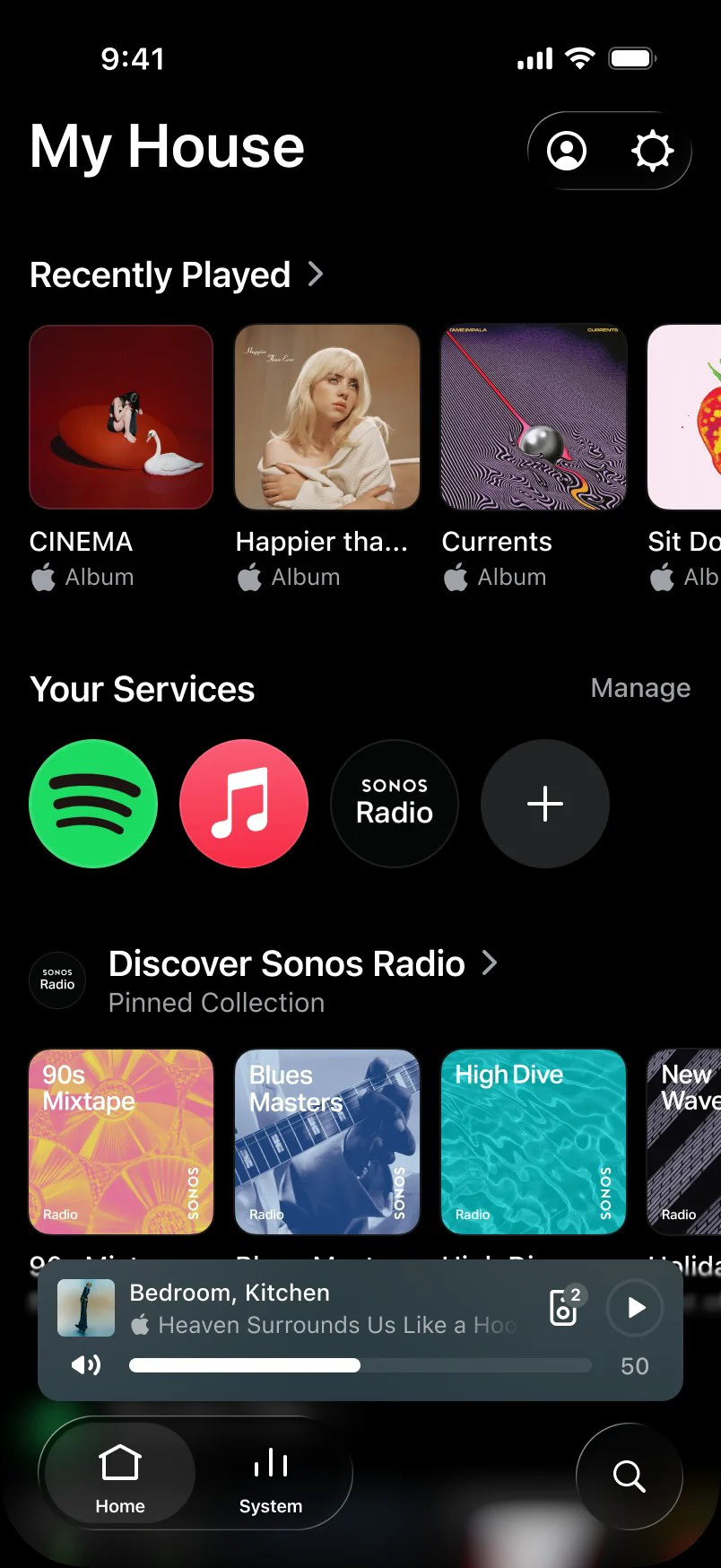 Sonos app Home screen in dark mode showing recently played albums, music services including Spotify, Apple Music, and Sonos Radio, plus a compact now-playing bar controlling grouped Bedroom and Kitchen speakers.