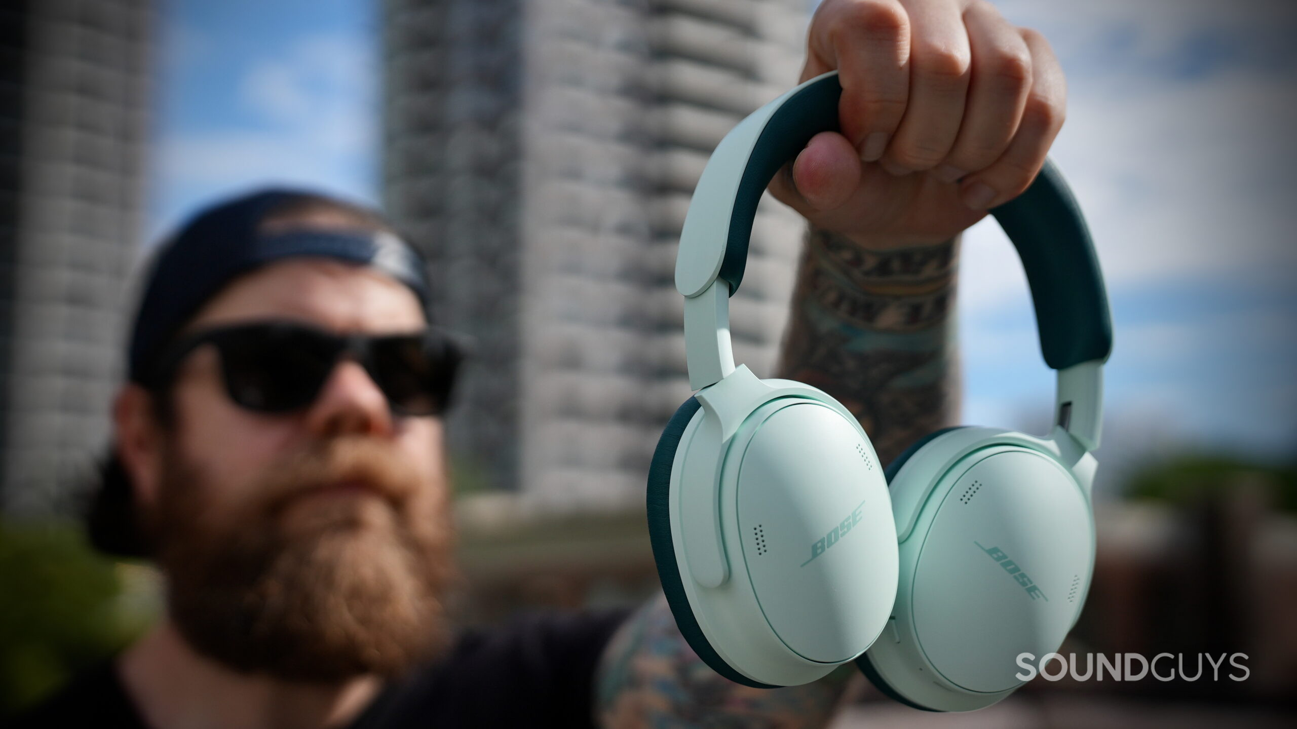 Bose QC Headphones (2nd Gen) - 12 The Bose QuietComfort Headphones (2nd Gen) in green held up outdoors.
