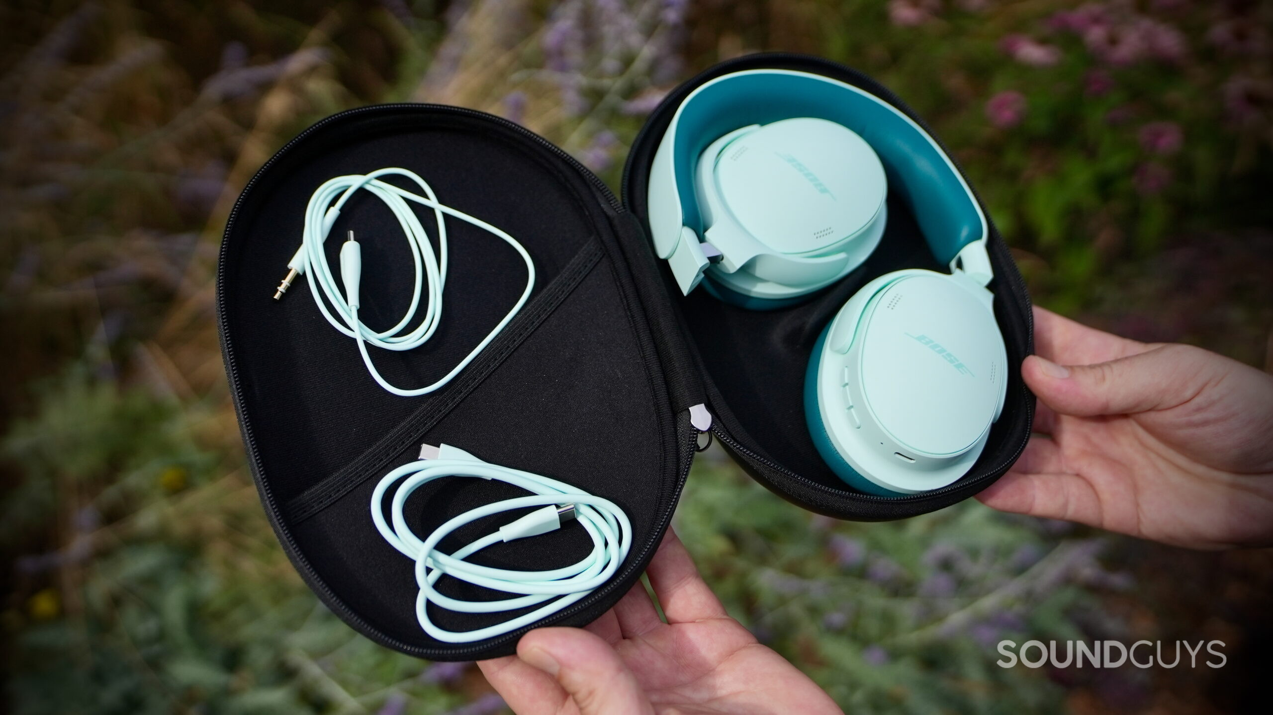 The Bose QuietComfort Headphones (2nd Gen), charging cable, and audio cable inside the carrying case.