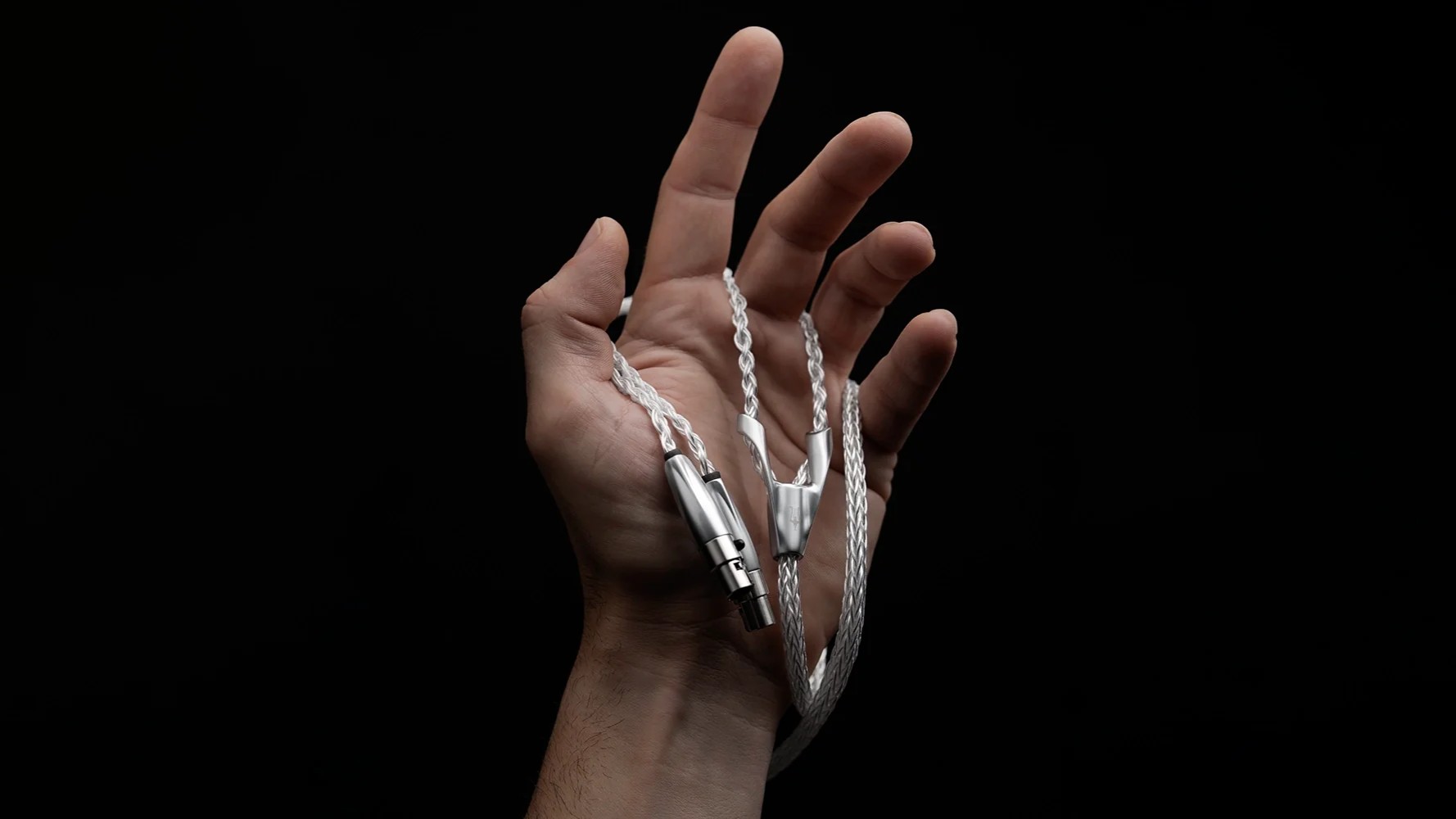 Meze-Audio-ULTRA_cable_-_07 a hand holding the meze audio ultra cable against a black background