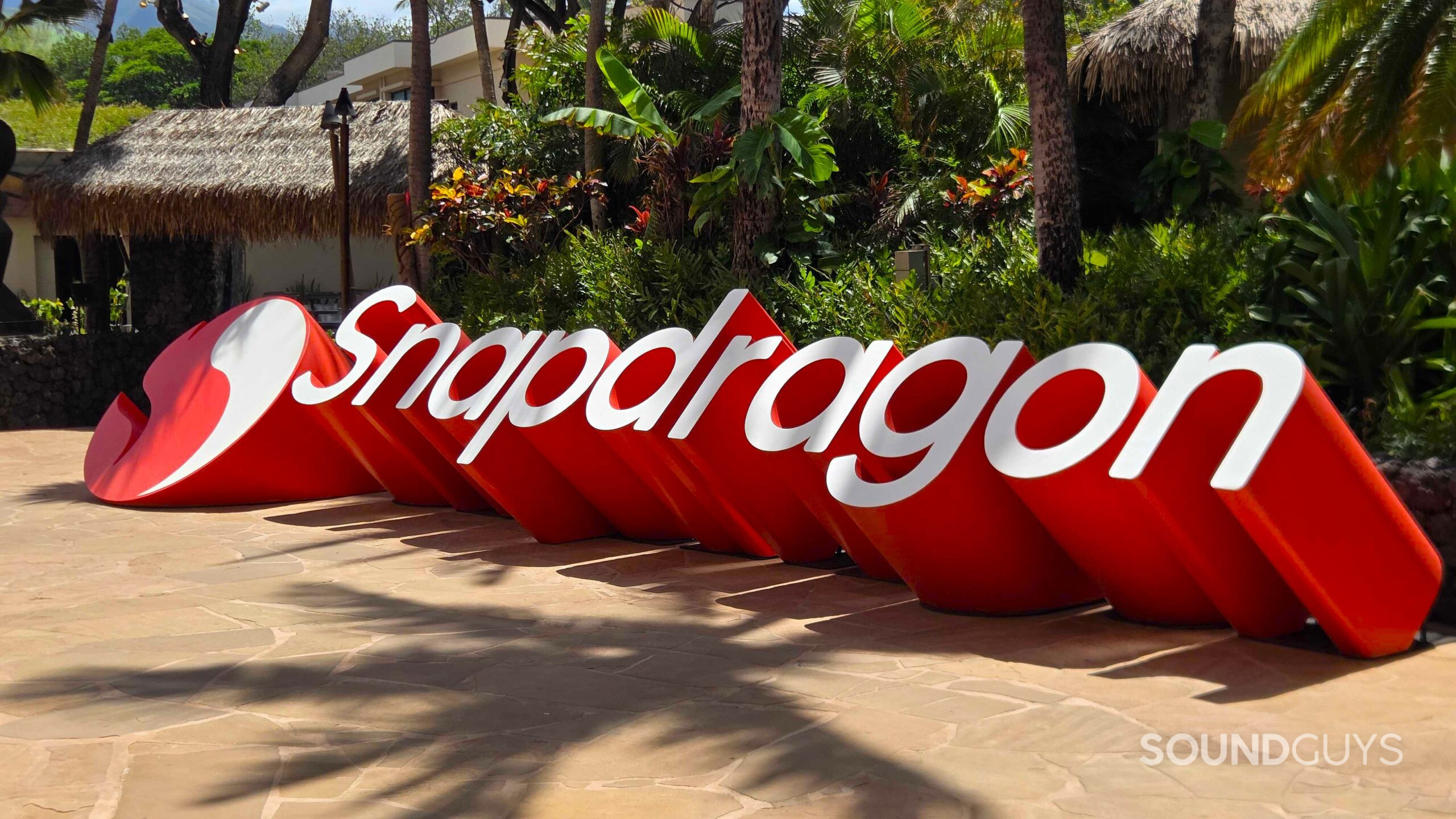 20260922_115745 A large red and white Snapdragon sign stands outside among palm trees and tropical plants.