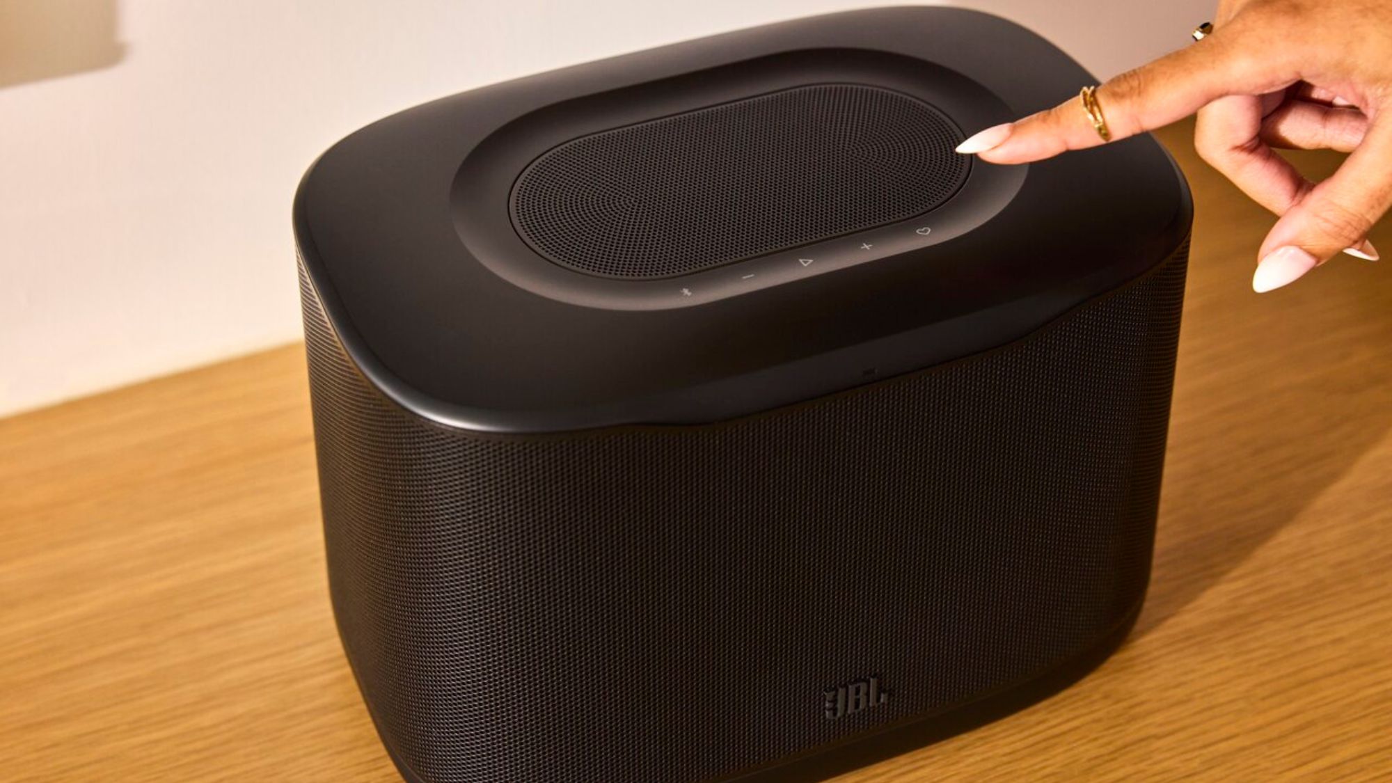 A person using the JBL Cove speaker