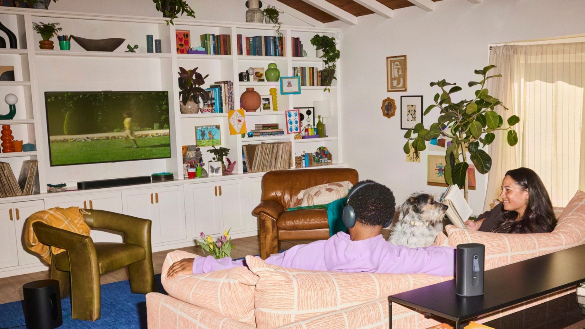 A person watching TV while keeping the Sonos Ace Ultra connected to it