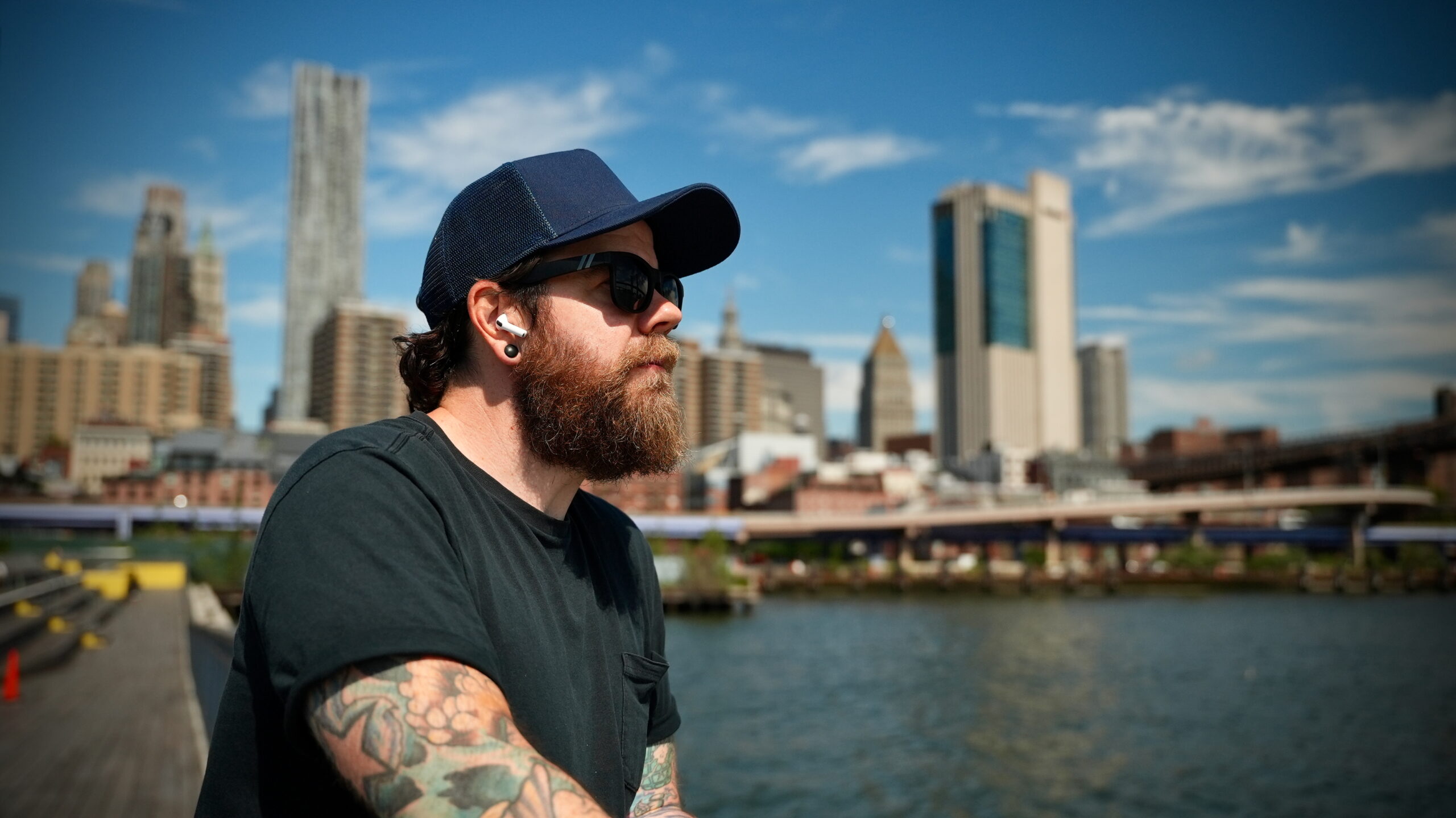 A man wearing AirPods in New York City with the skyline in the background.