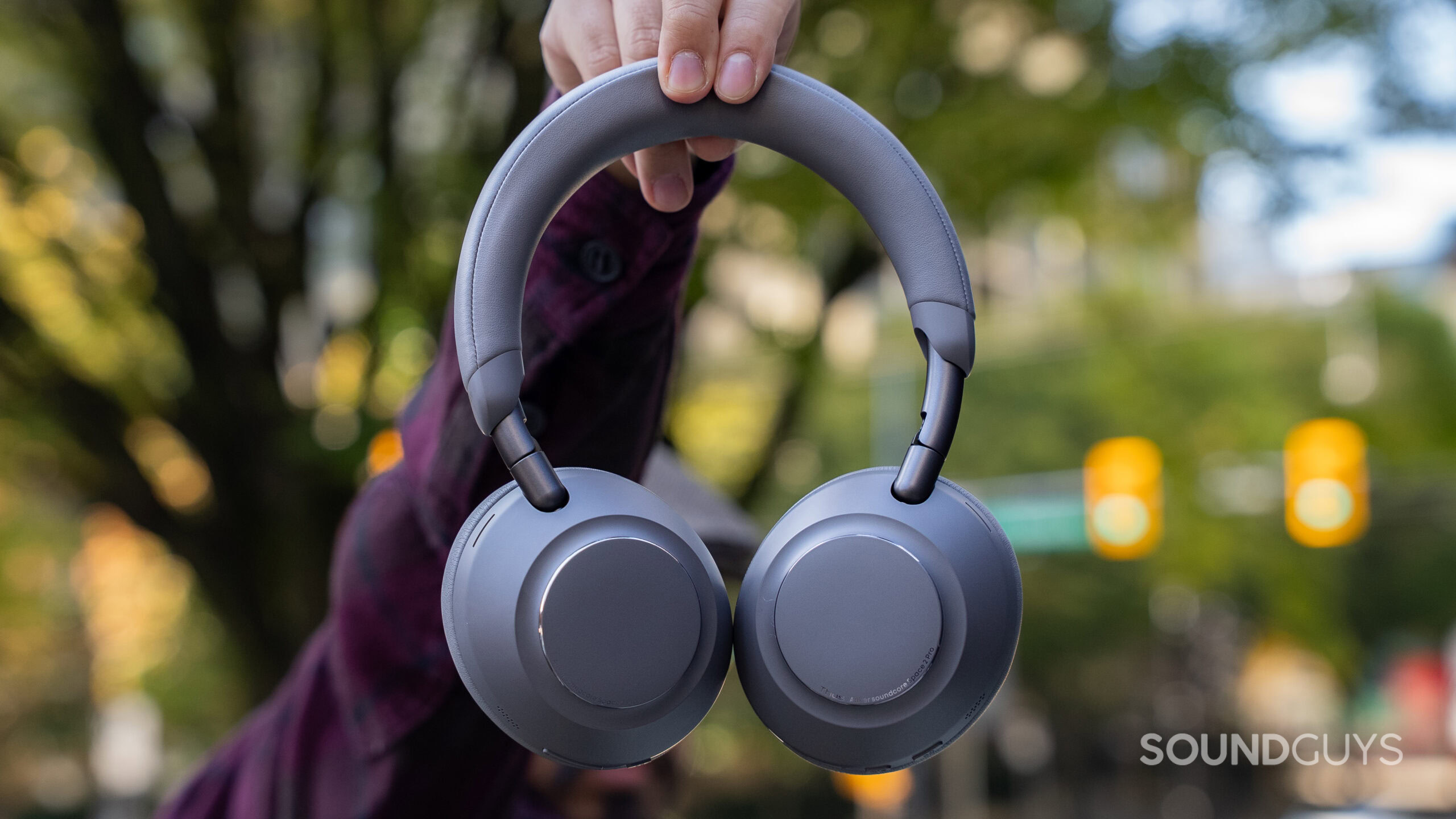 Anker Soundcore Space 2 Pro hero outdoor A man holding the Anker Soundcore Space 2 Pro headphones