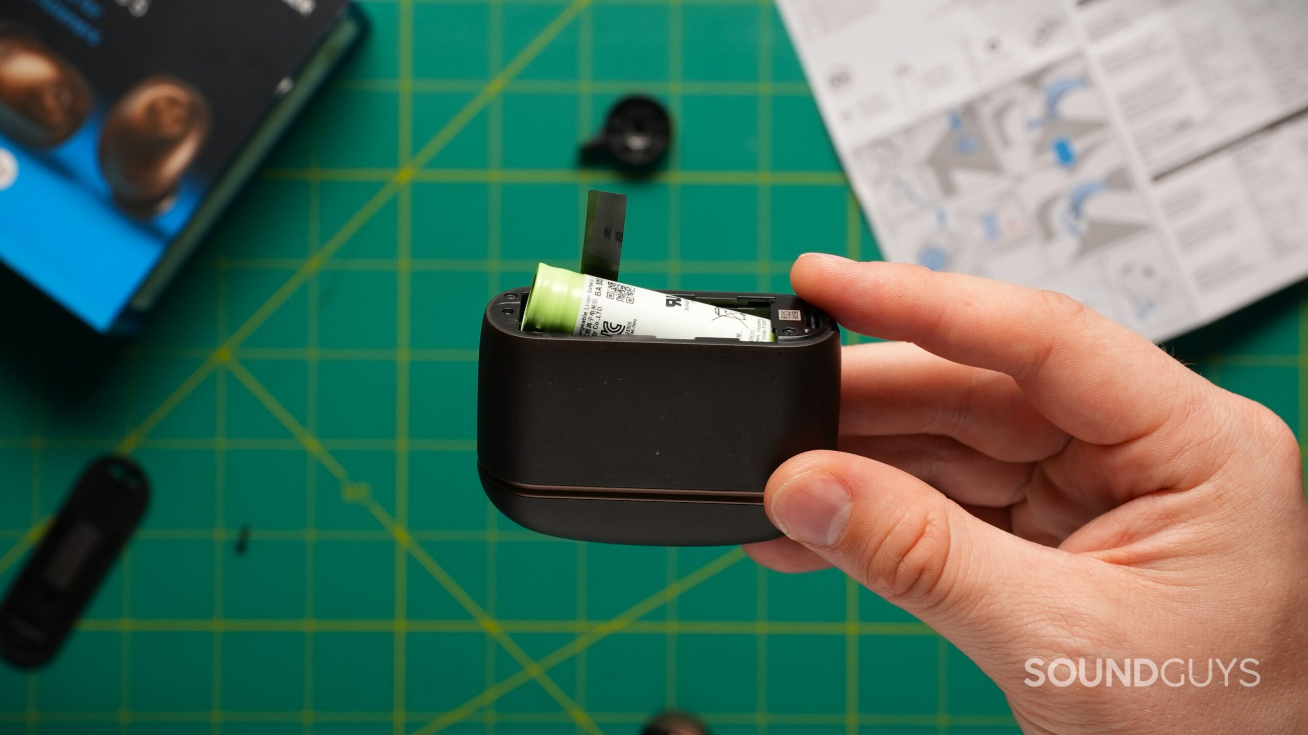 MTW5 case battery A hand holds the opened Sennheiser Momentum True Wireless 5 charging case, exposing its cylindrical internal battery.
