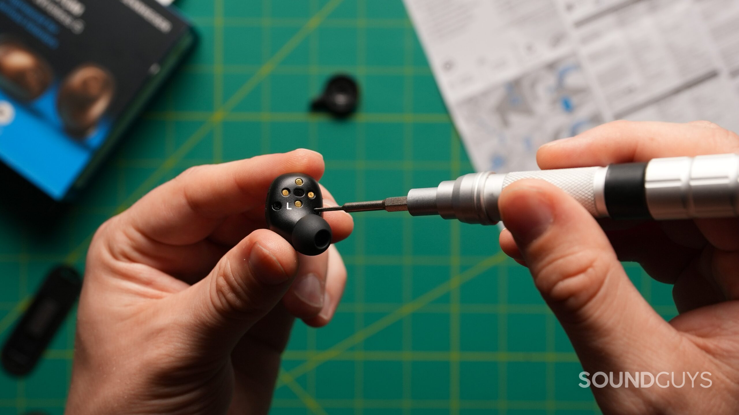 MTW5 earbuds screw A person uses a precision screwdriver to disassemble a black Sennheiser Momentum True Wireless 5 earbud.
