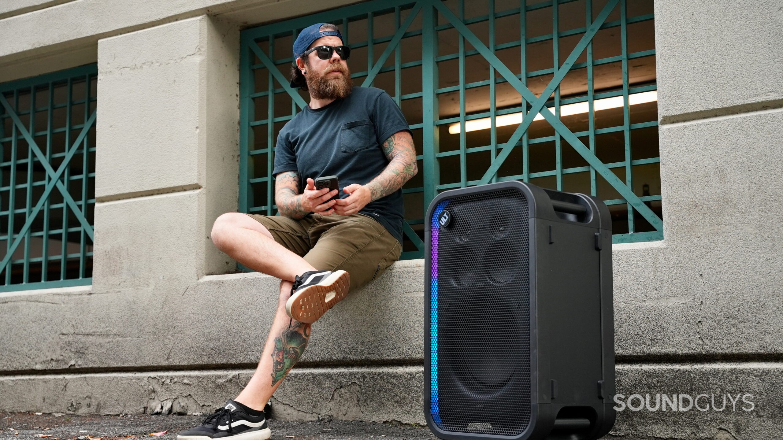 Sony ULT series - 16 Sony ULT TOWER 7 standing beside a seated person outdoors.